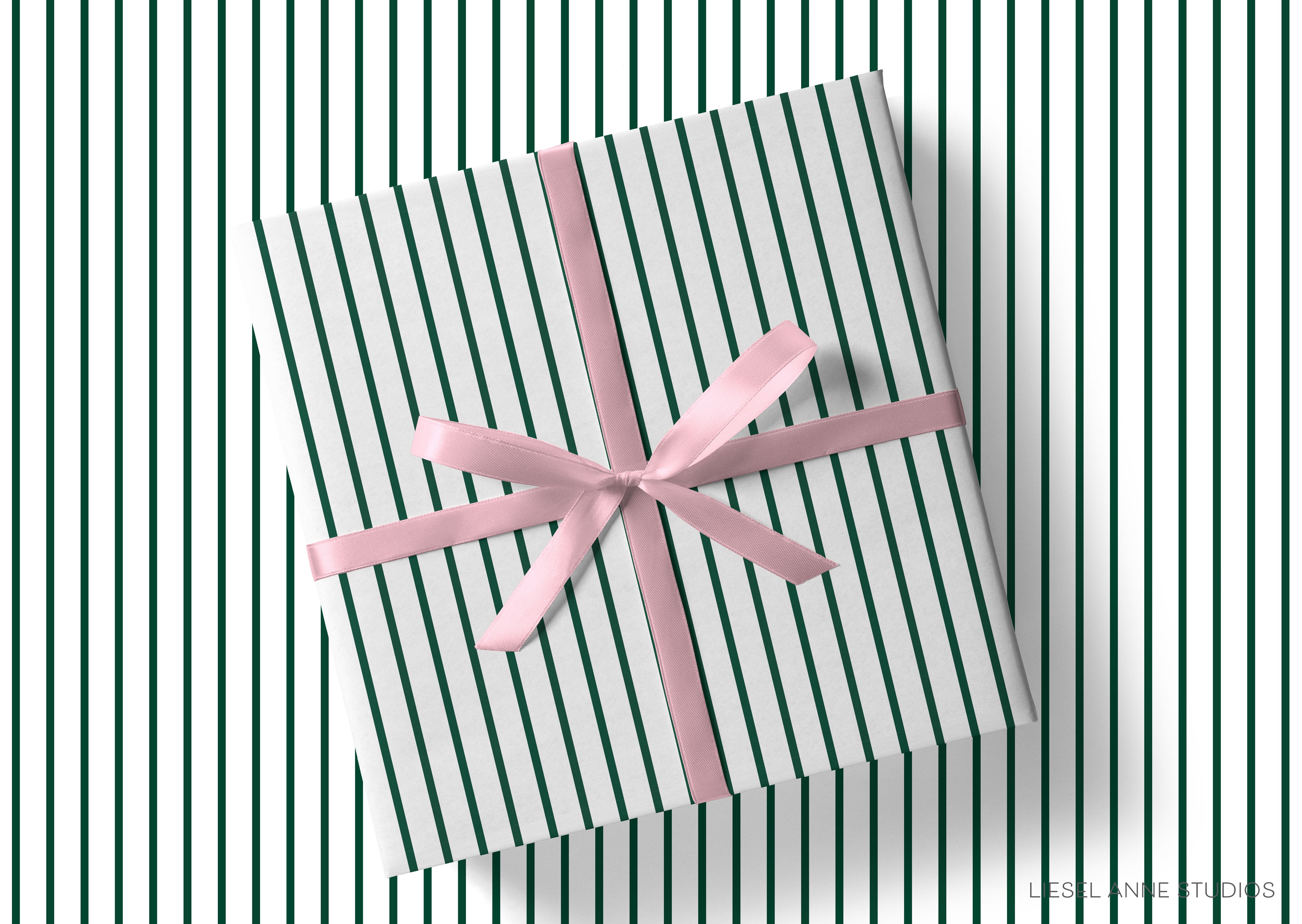 A gift box with a pink ribbon tied around it, placed on a striped background.