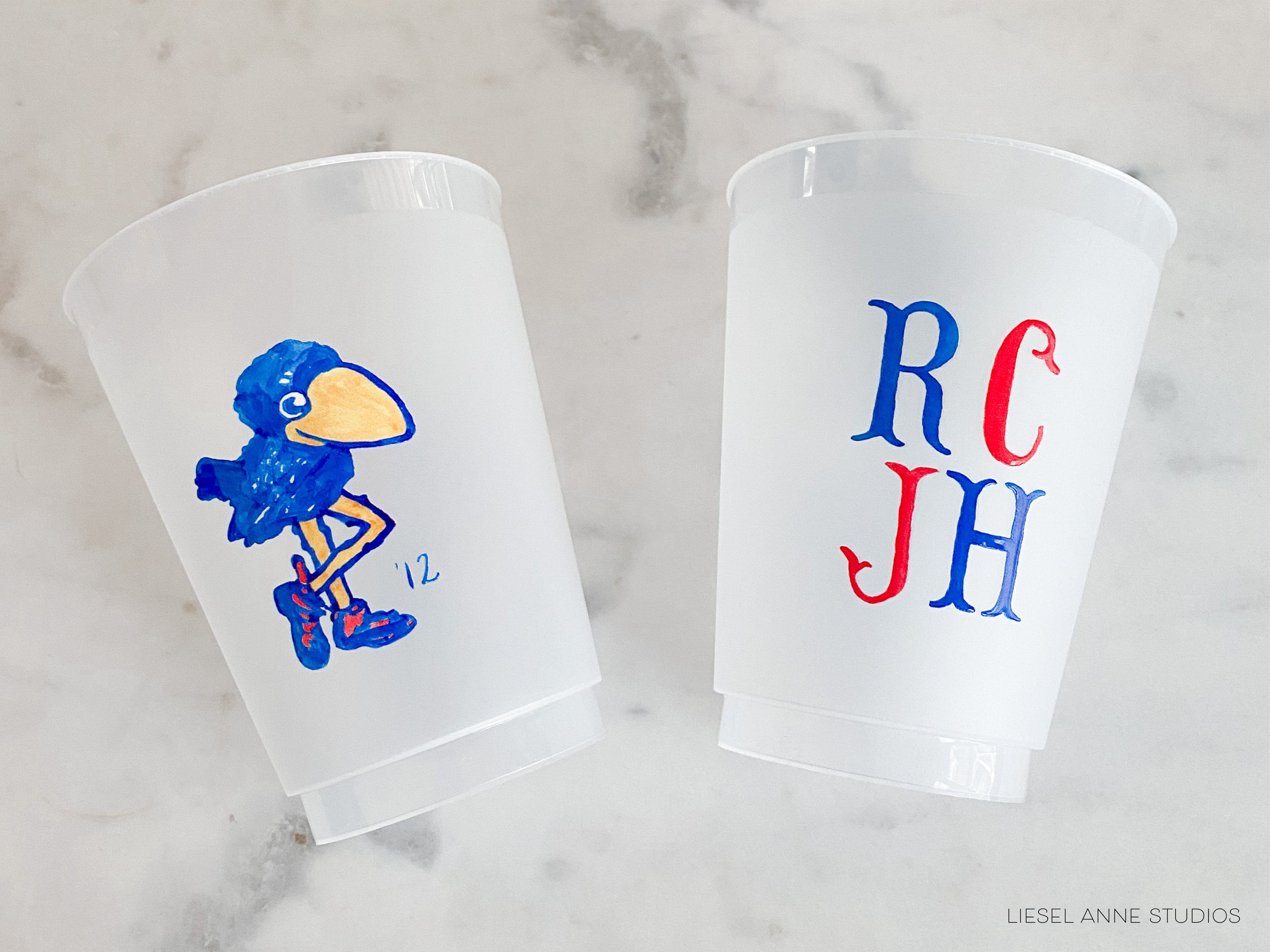 two white plastic cups with colorful designs on them.