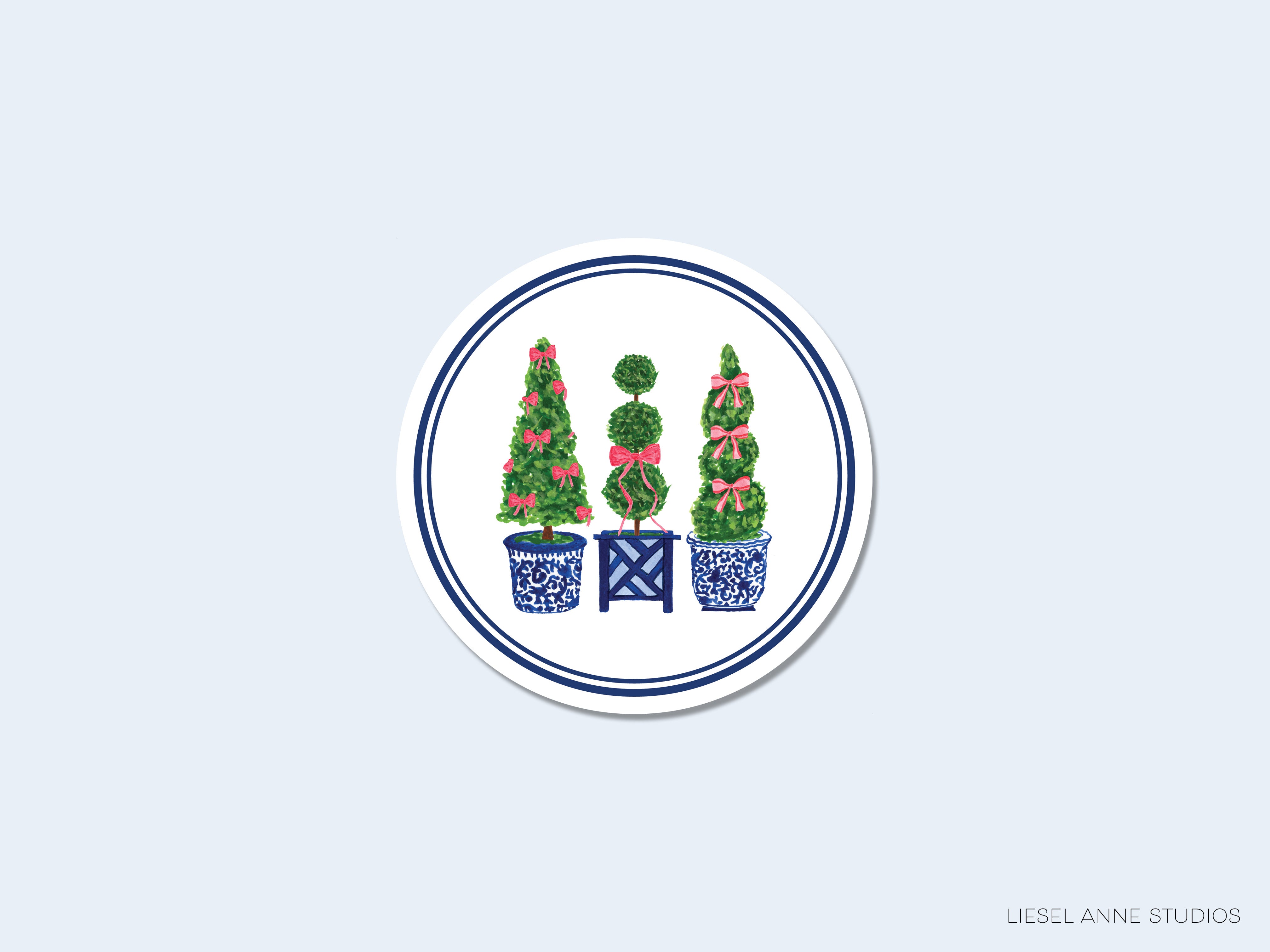 A circular plate with three decorative topiary trees in blue and white pots, surrounded by a blue border.