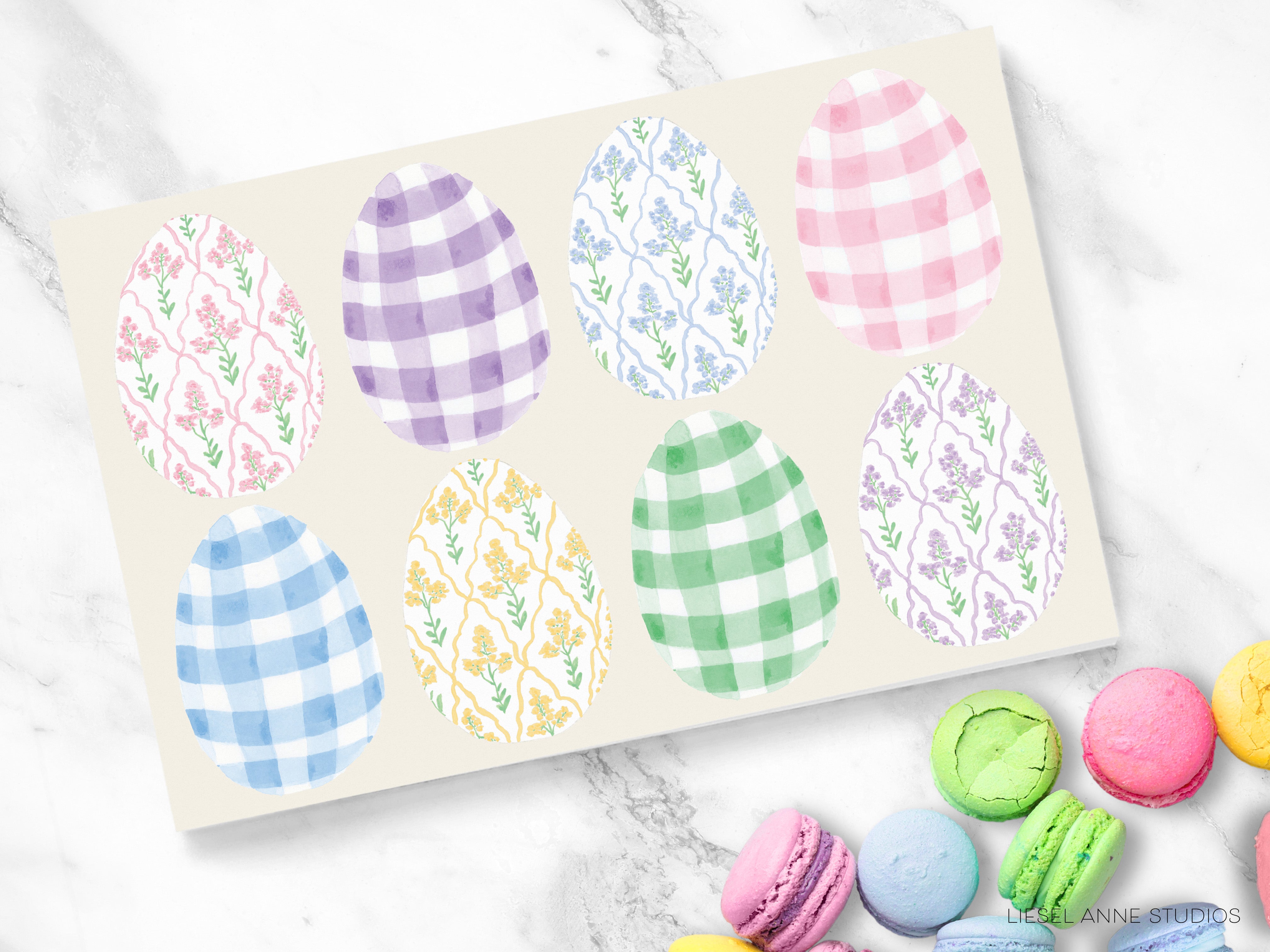 A collection of colorful Easter eggs with various patterns, including plaid, floral, and polka dot designs, along with a variety of macarons or cookies on a marble surface.