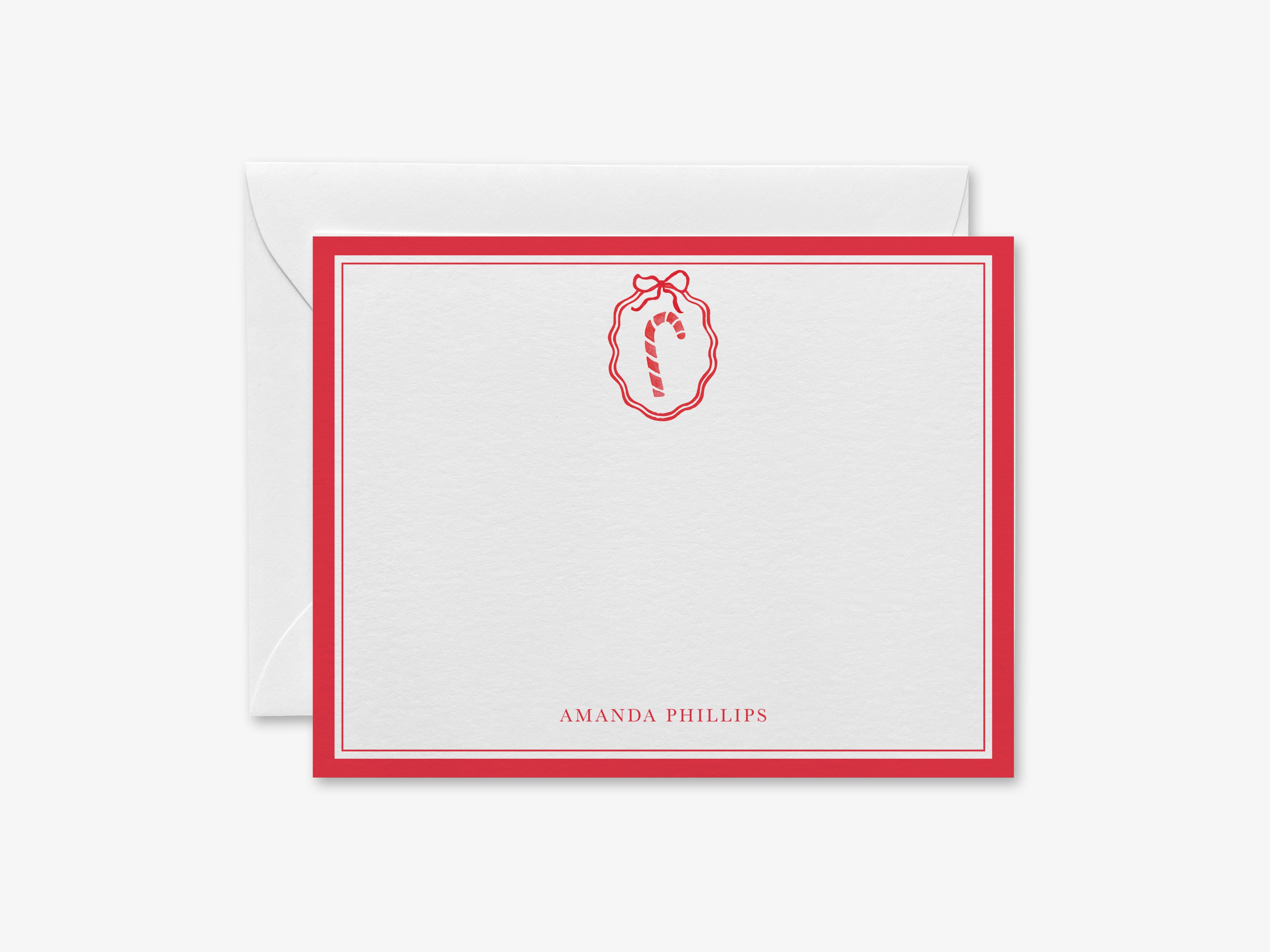 A white envelope with a red border and a red and white label featuring a red ribbon and a red candy cane.
