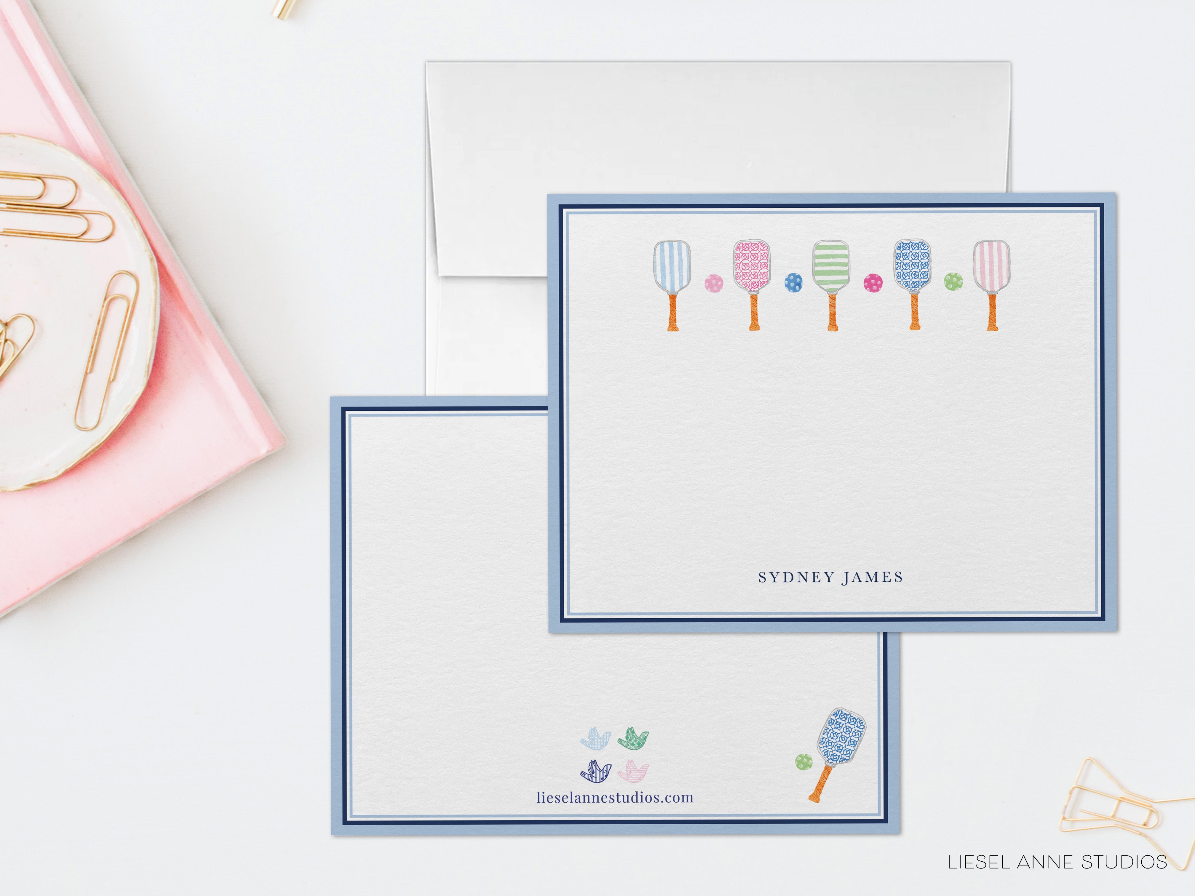 two blank cards with illustrations of paddleball players on them, placed on a white surface.