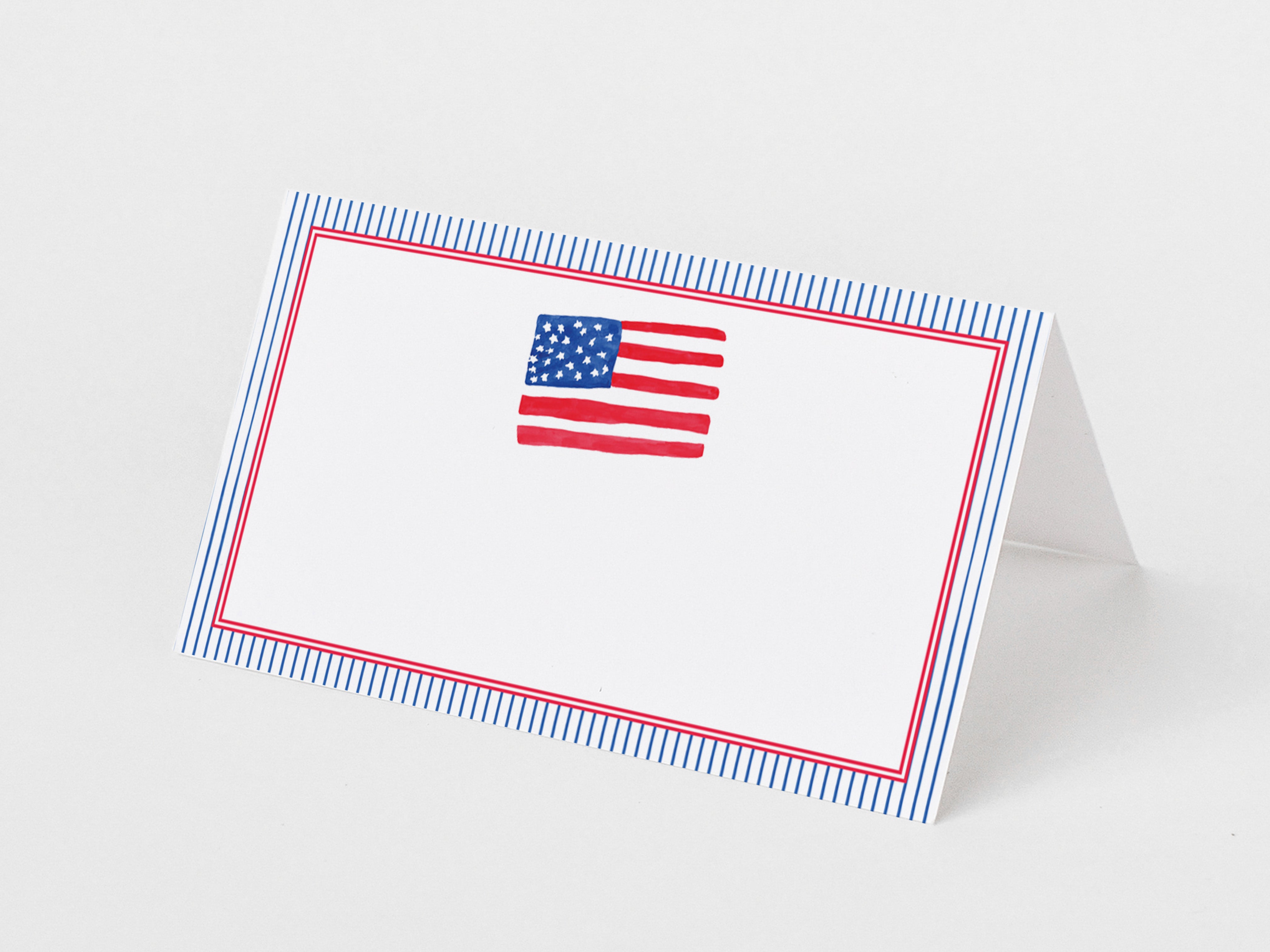a white card with a blue and red border, and a small American flag design on the center of the card.