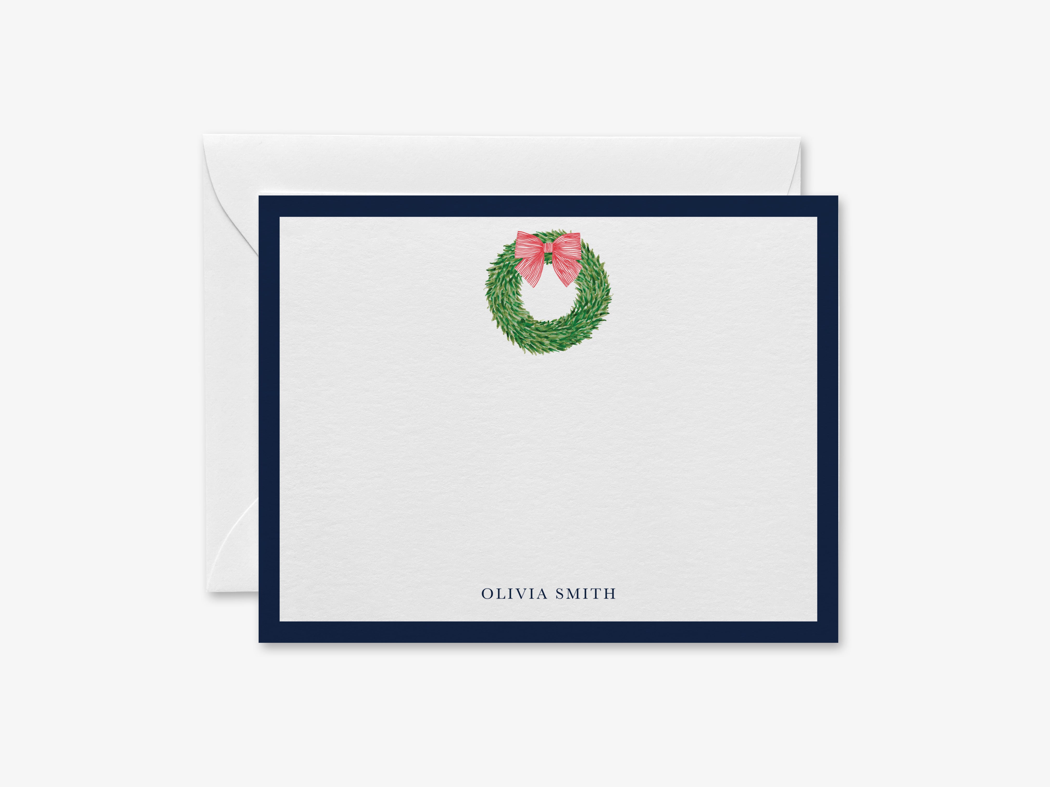 A white card with a blue border, featuring a wreath with a pink bow on it.
