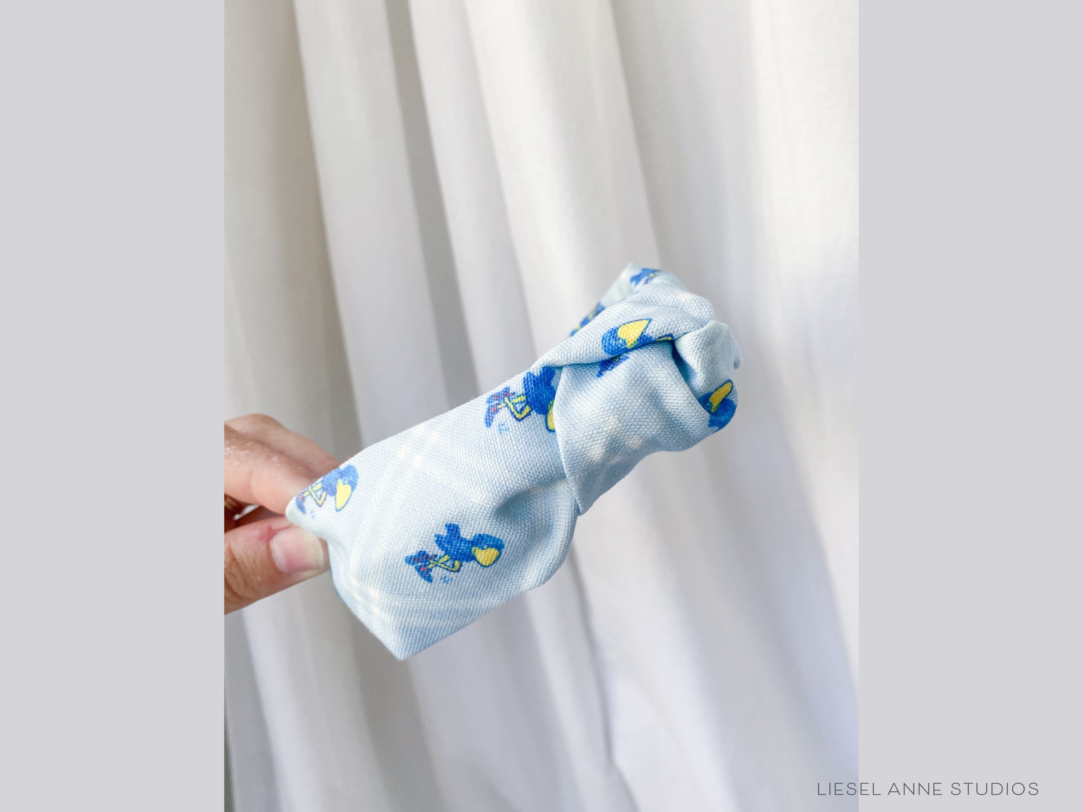 1912 Jayhawk Officially Licensed Light Blue Diamond Headband-These fabric headbands make unique one-of-a-kind gifts as each one is slightly different. They are cut from our hand-painted signature print. These are the perfect accessory and make great gifts!-The Singing Little Bird