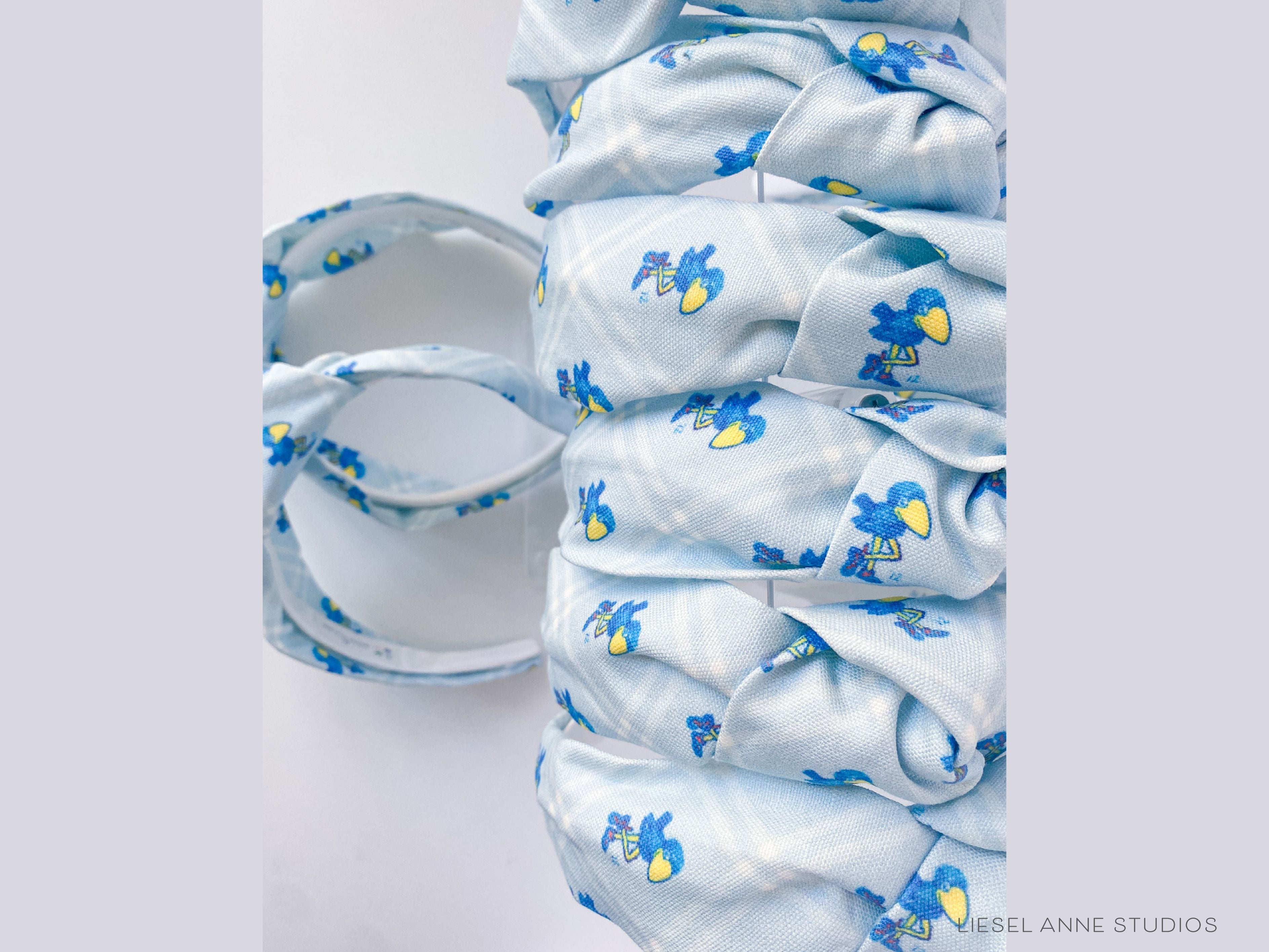 1912 Jayhawk Officially Licensed Light Blue Diamond Headband-These fabric headbands make unique one-of-a-kind gifts as each one is slightly different. They are cut from our hand-painted signature print. These are the perfect accessory and make great gifts!-The Singing Little Bird
