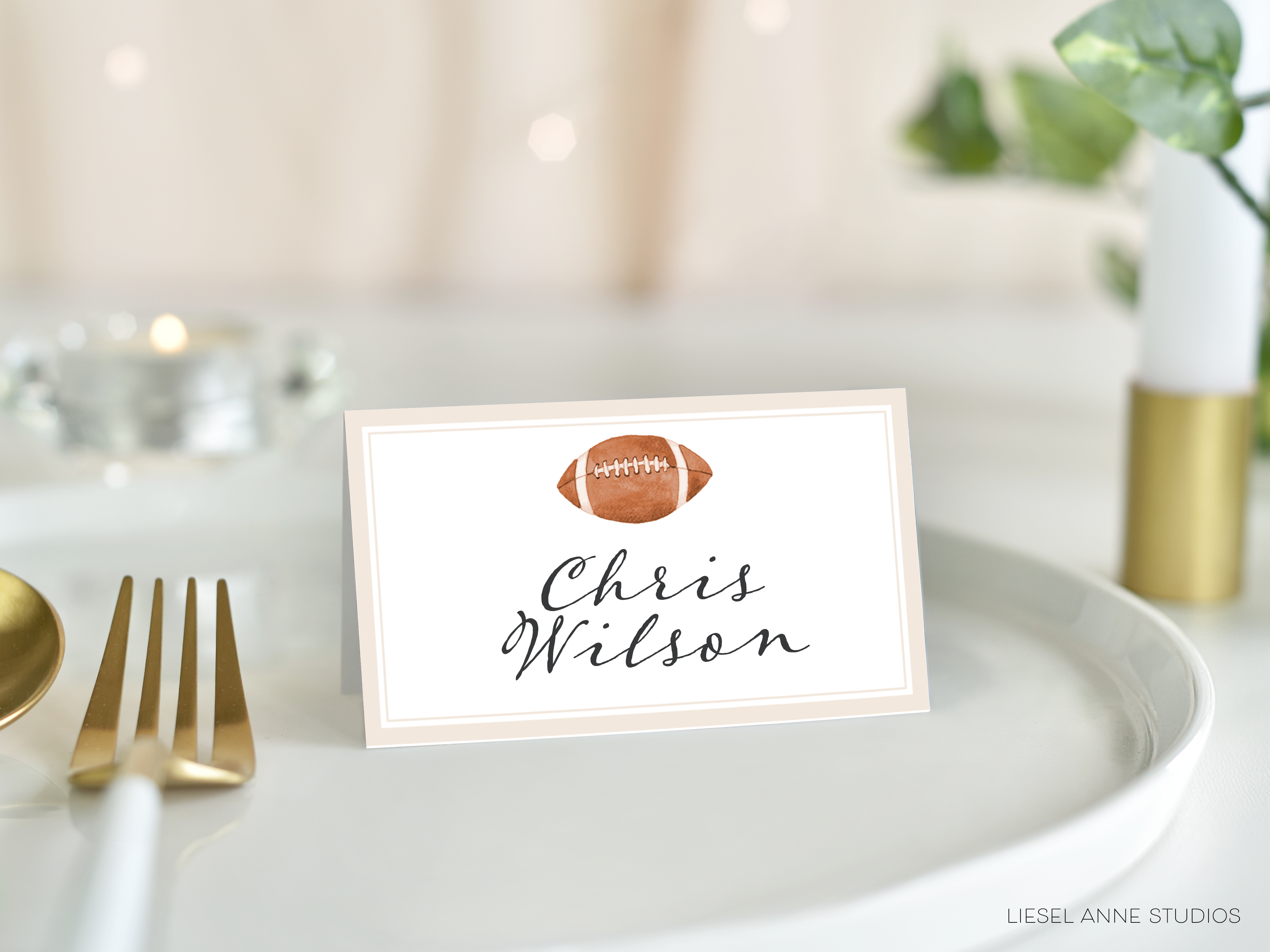 A place card with a football on it, placed on a white tablecloth.