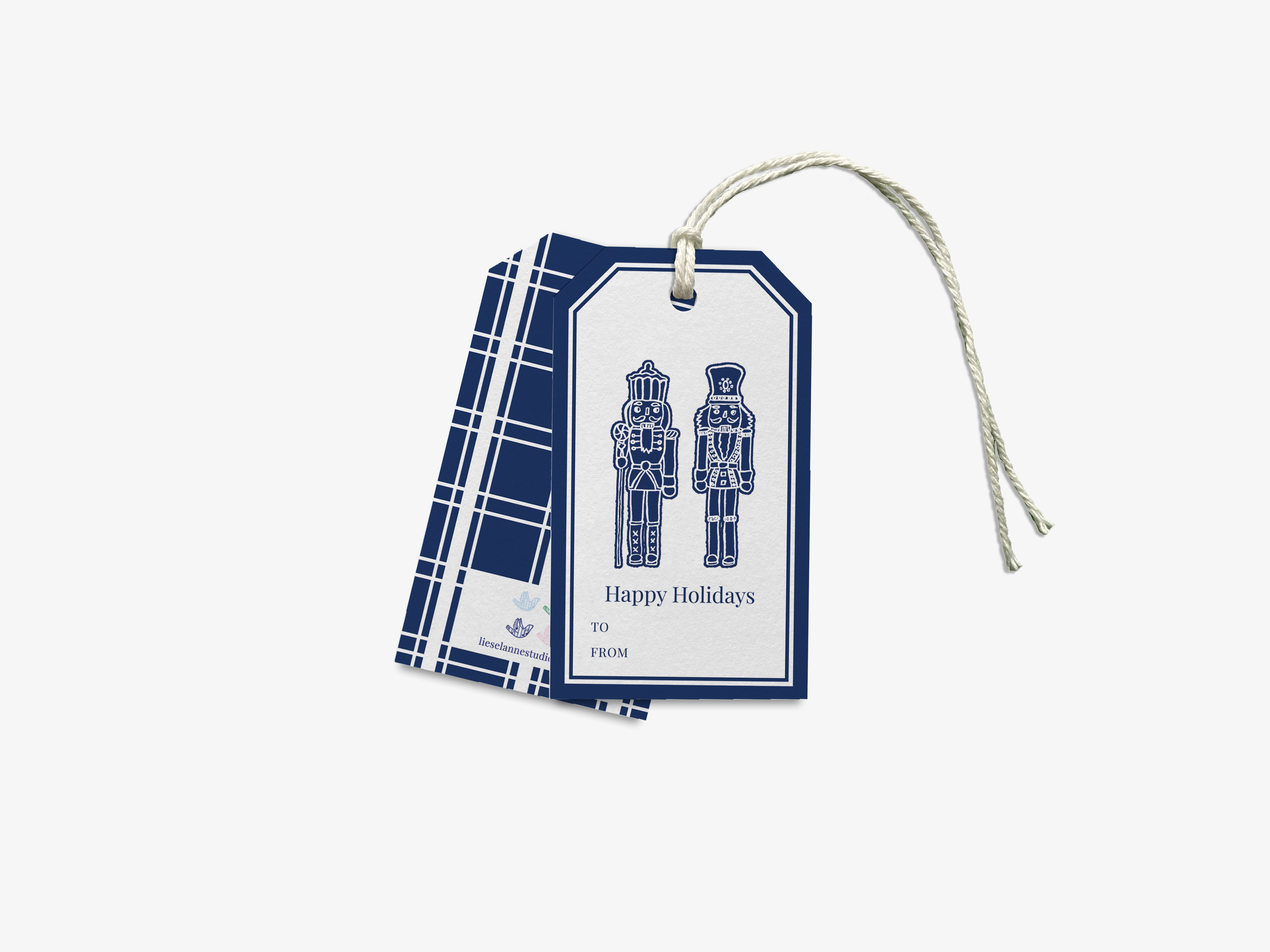 A blue and white gift tag with a white border and a white ribbon. The tag features an illustration of two nutcrackers and the text "Happy Holidays" and "To" followed by "FROM".