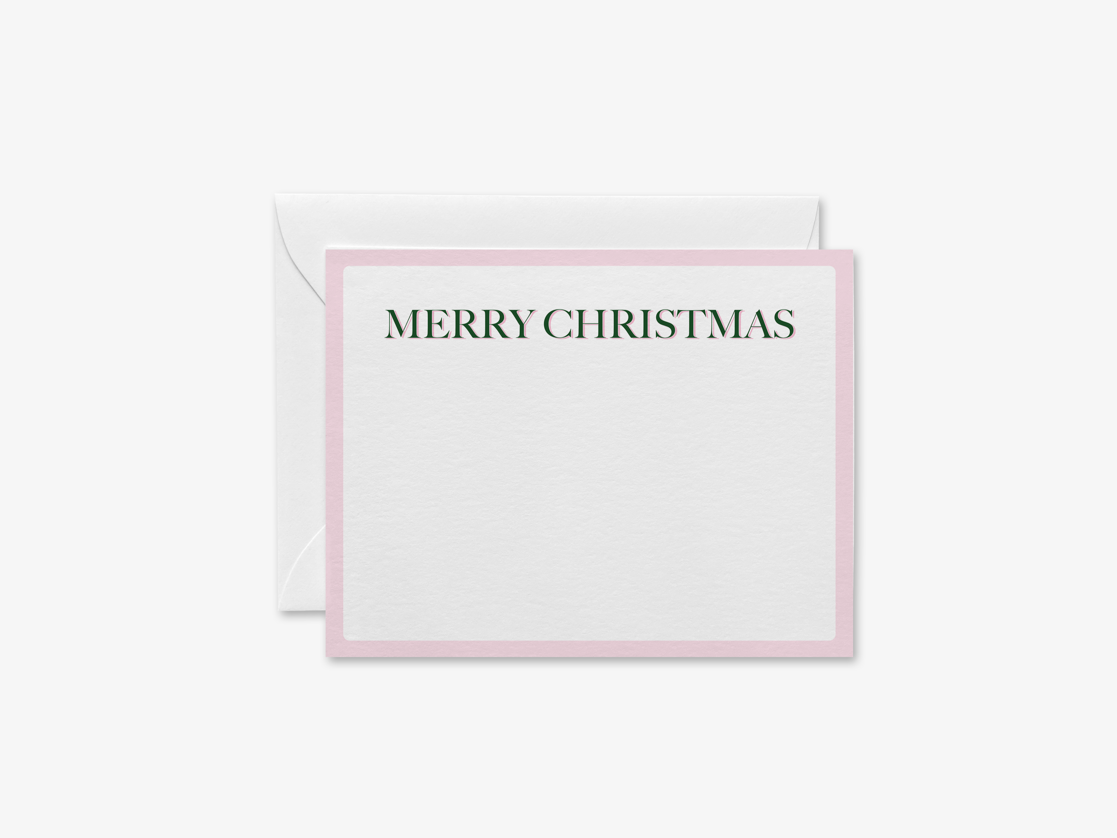 A white greeting card with a pink border and the text "MERRY CHRISTMAS" printed on it.