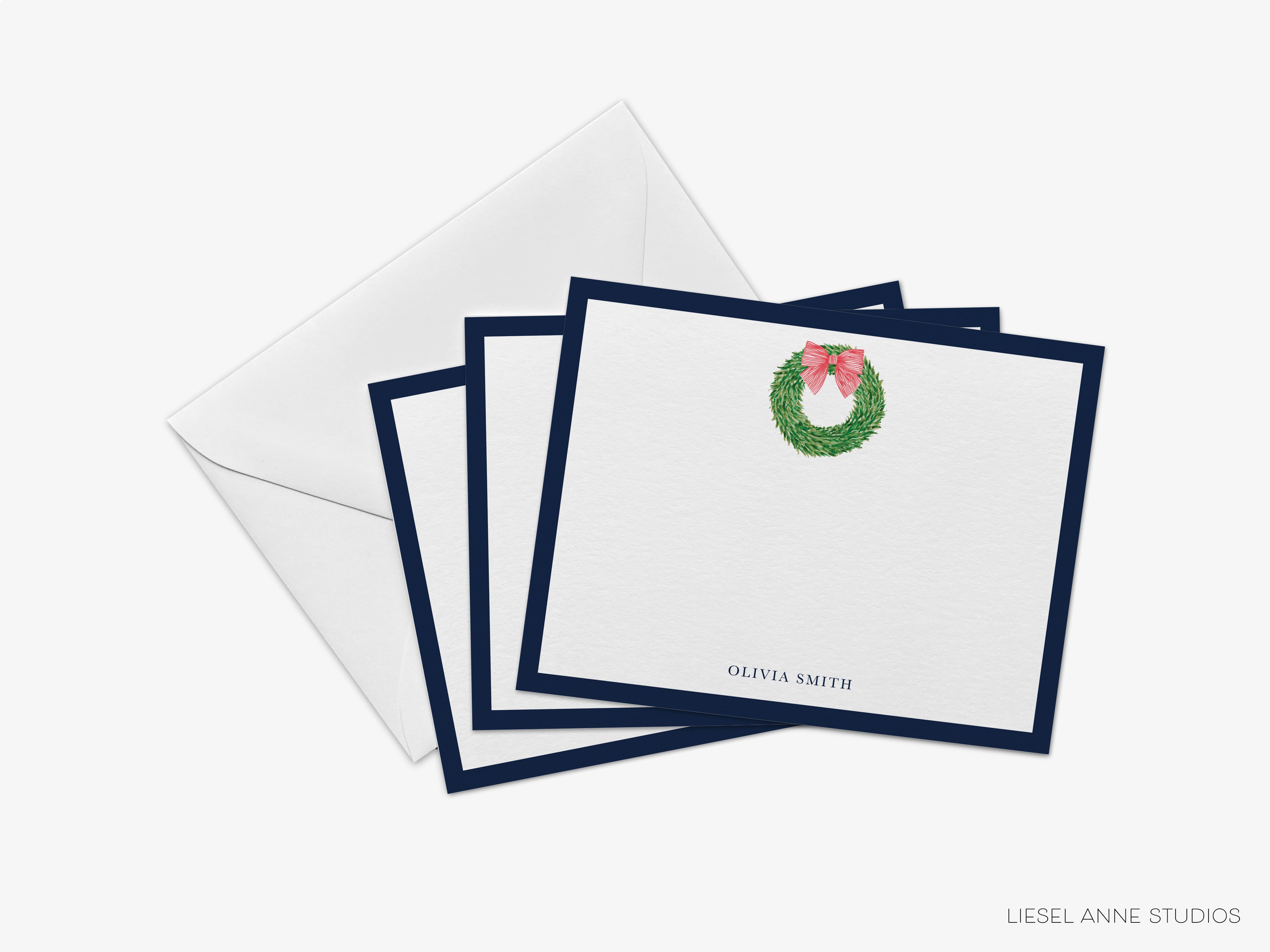 A set of four square greeting cards with a wreath design and a nameplate on the front, placed on top of an envelope.