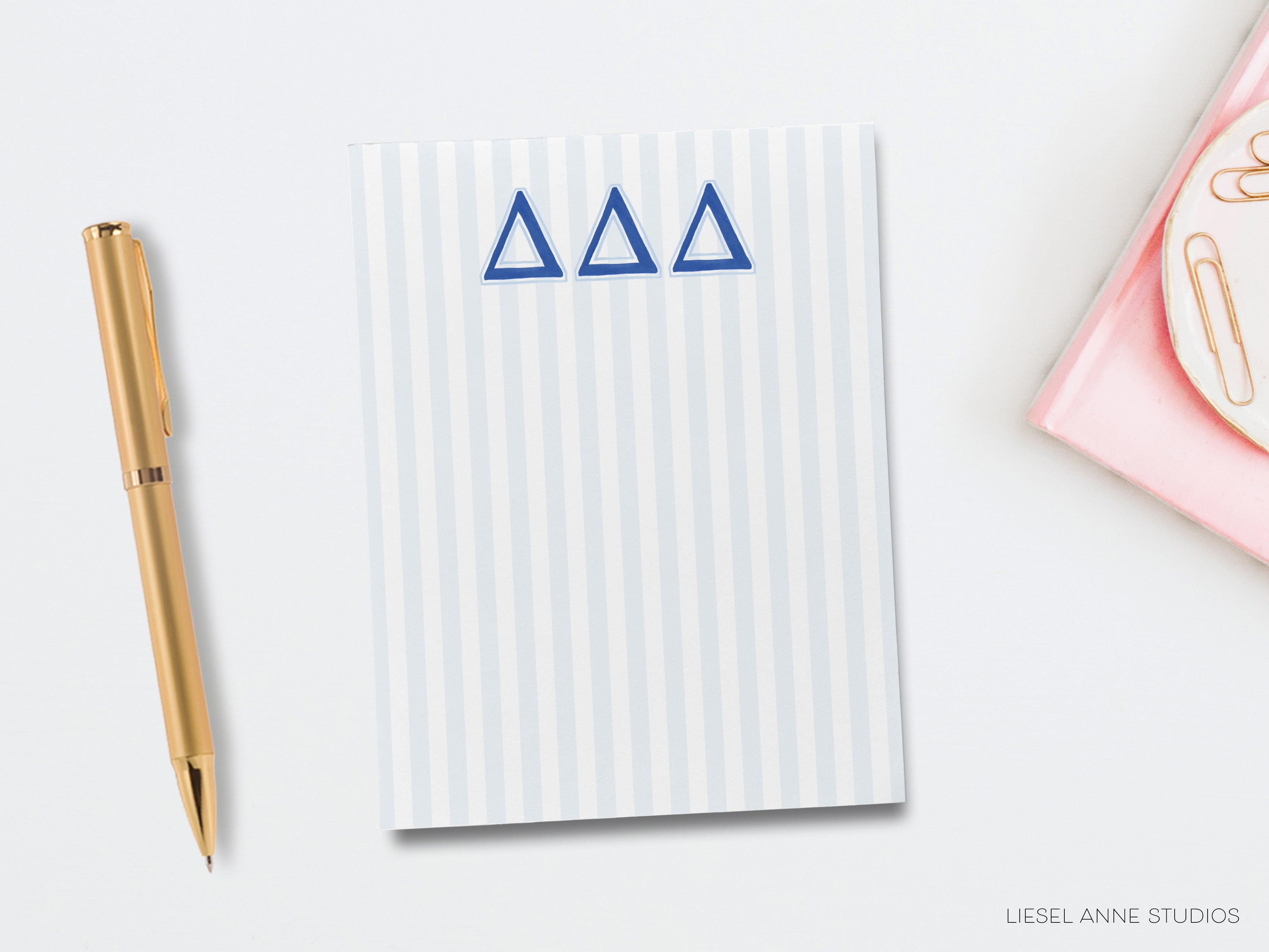 a notepad with a delta symbol on it next to a pen
