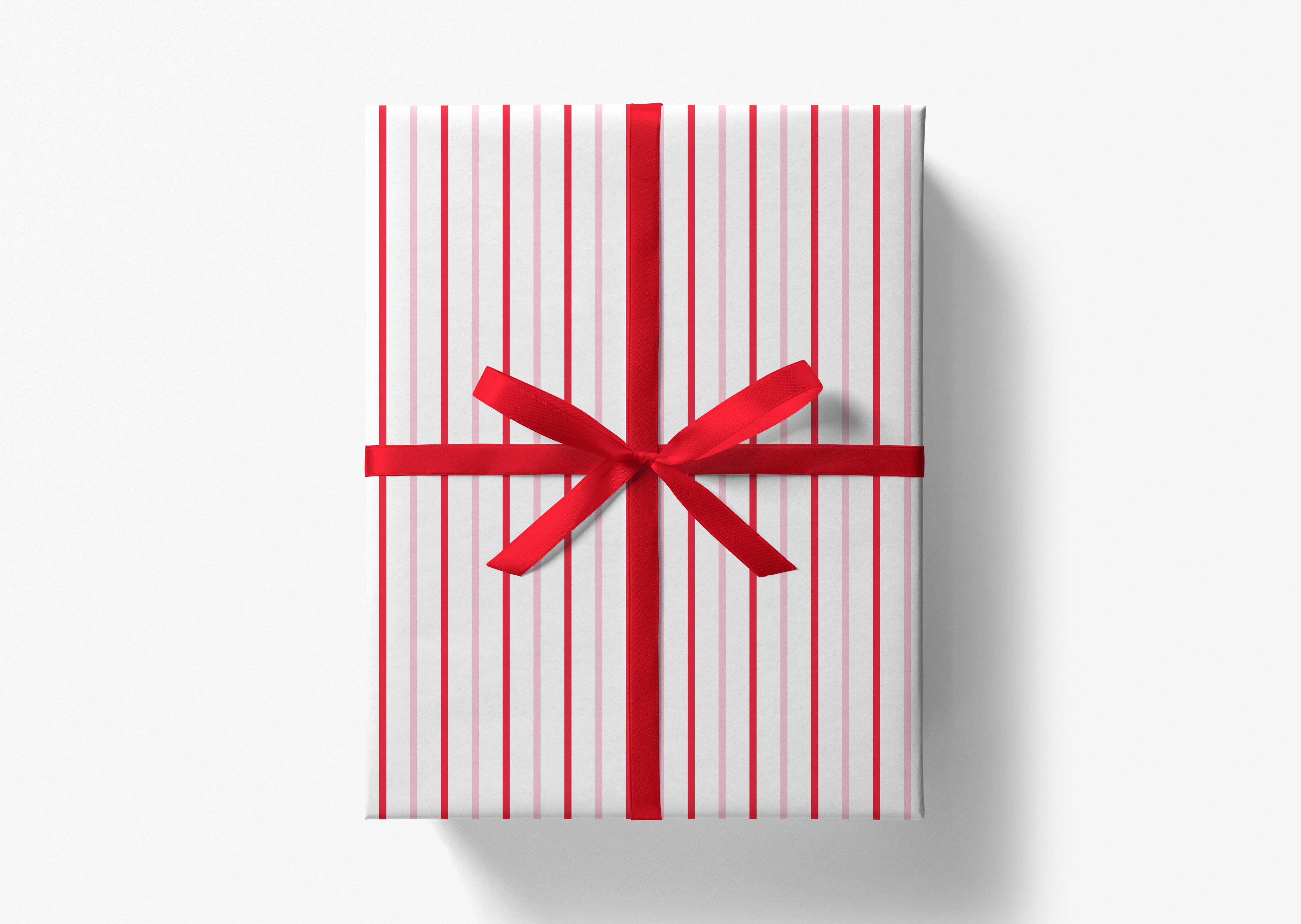 A gift box wrapped in white and red striped paper with a red ribbon bow tied around it.