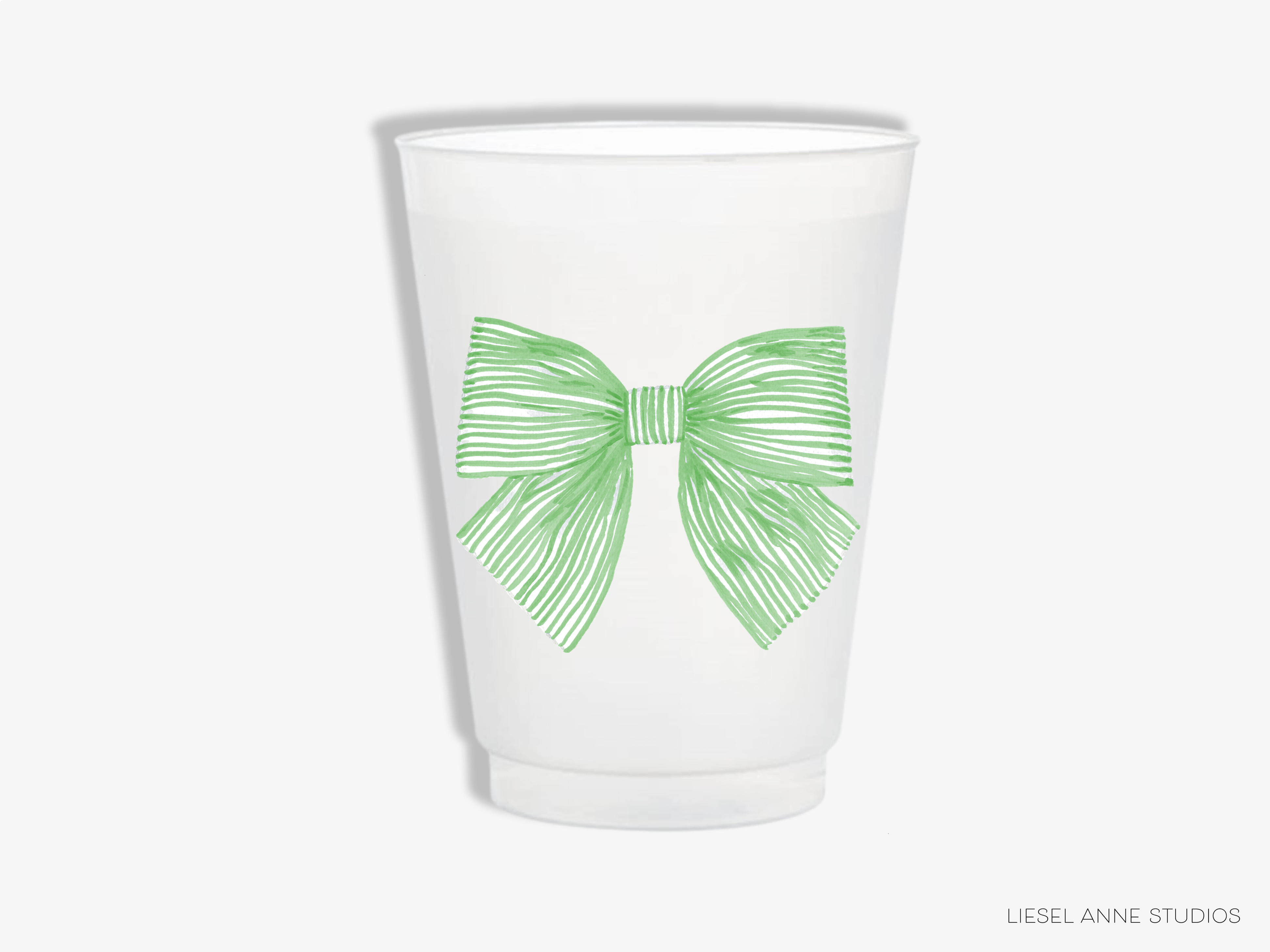 A white plastic cup with a green bow design on it.