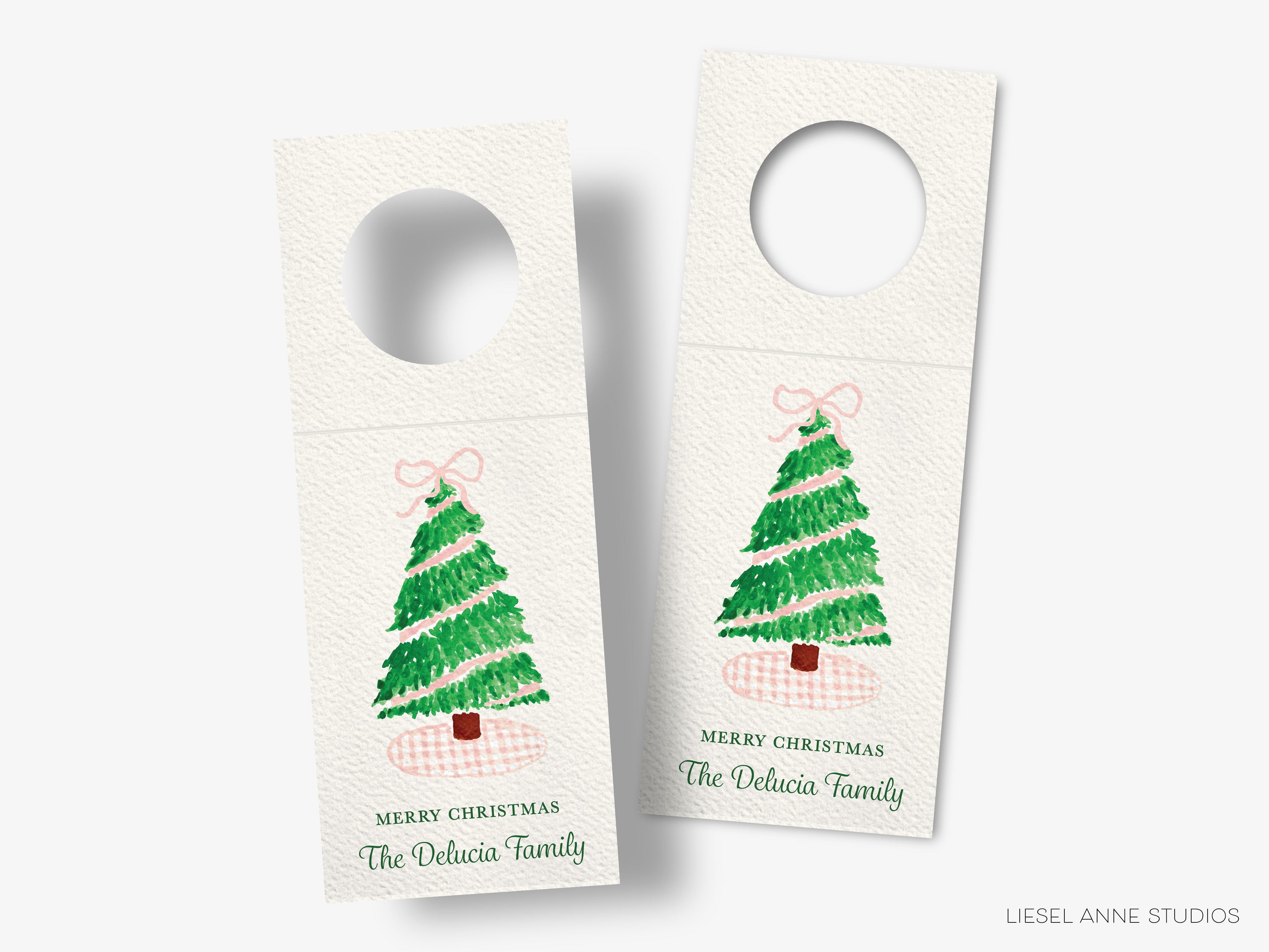 two identical Christmas tree-themed door tags with a bow on top, each displaying a Christmas tree and the text "Merry Christmas The Delicacia Family".