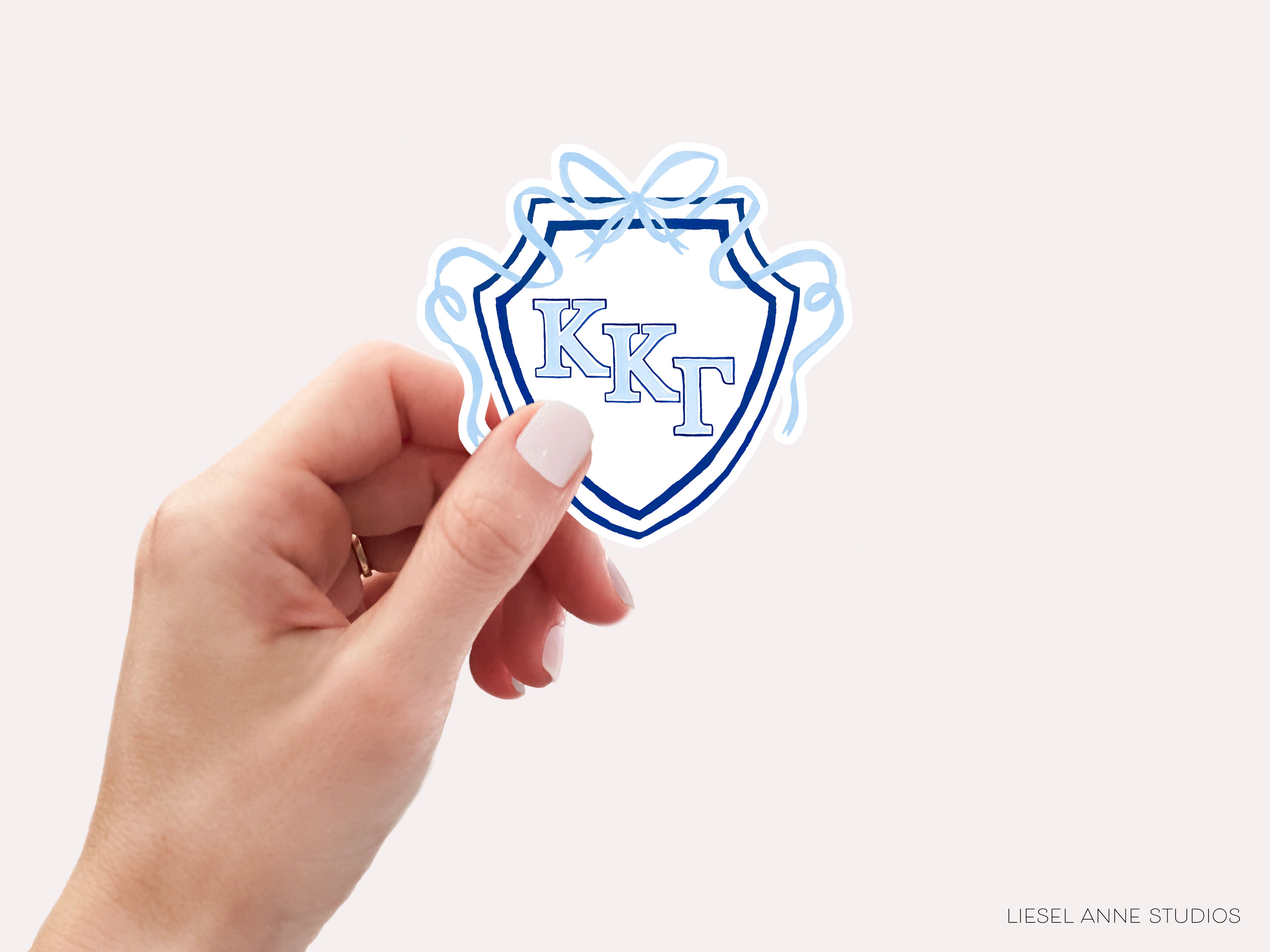 a hand holding a sticker with the letter k on it