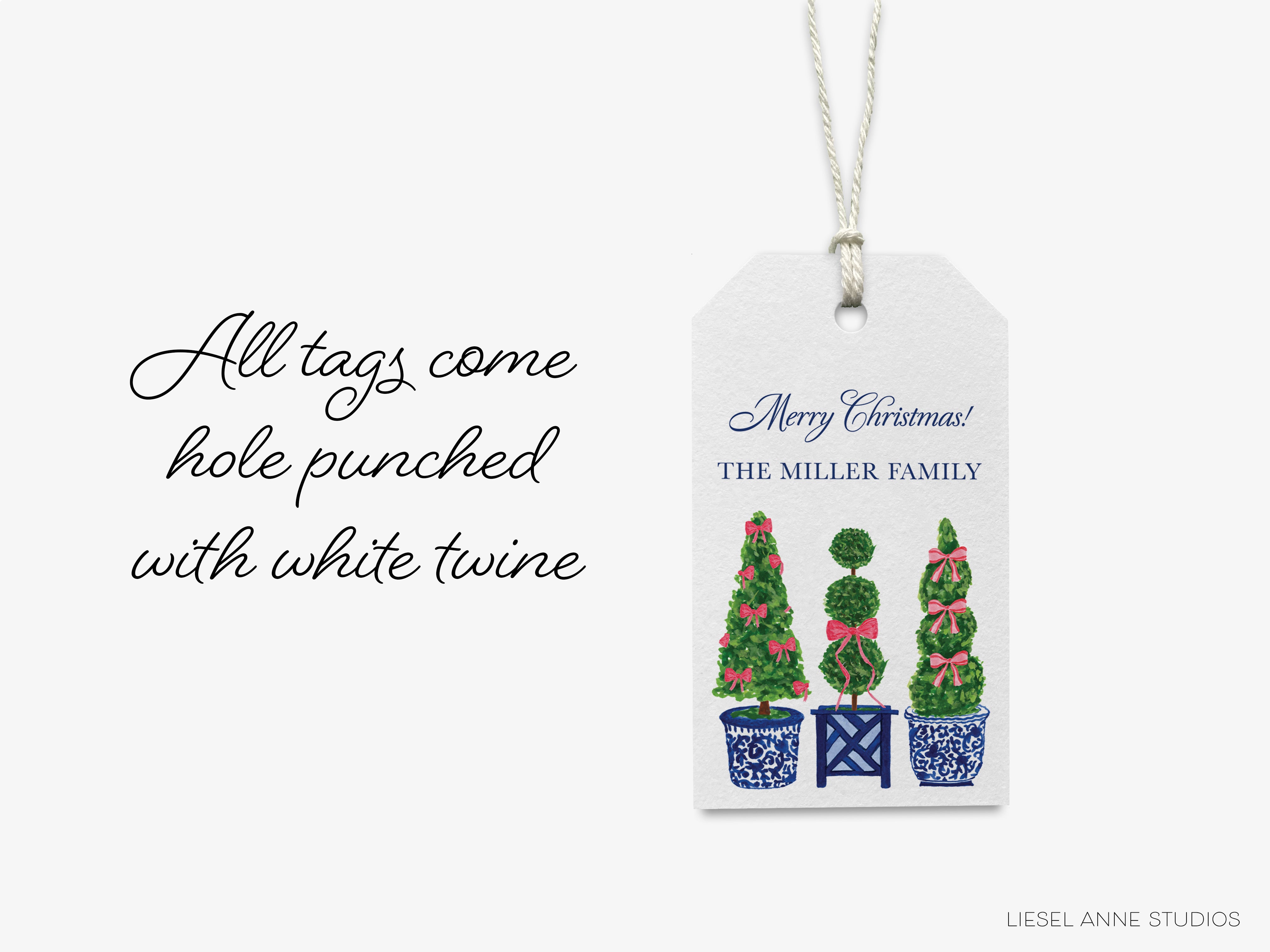 A white tag with a Christmas message and illustrations of three Christmas trees in blue and white pots.
