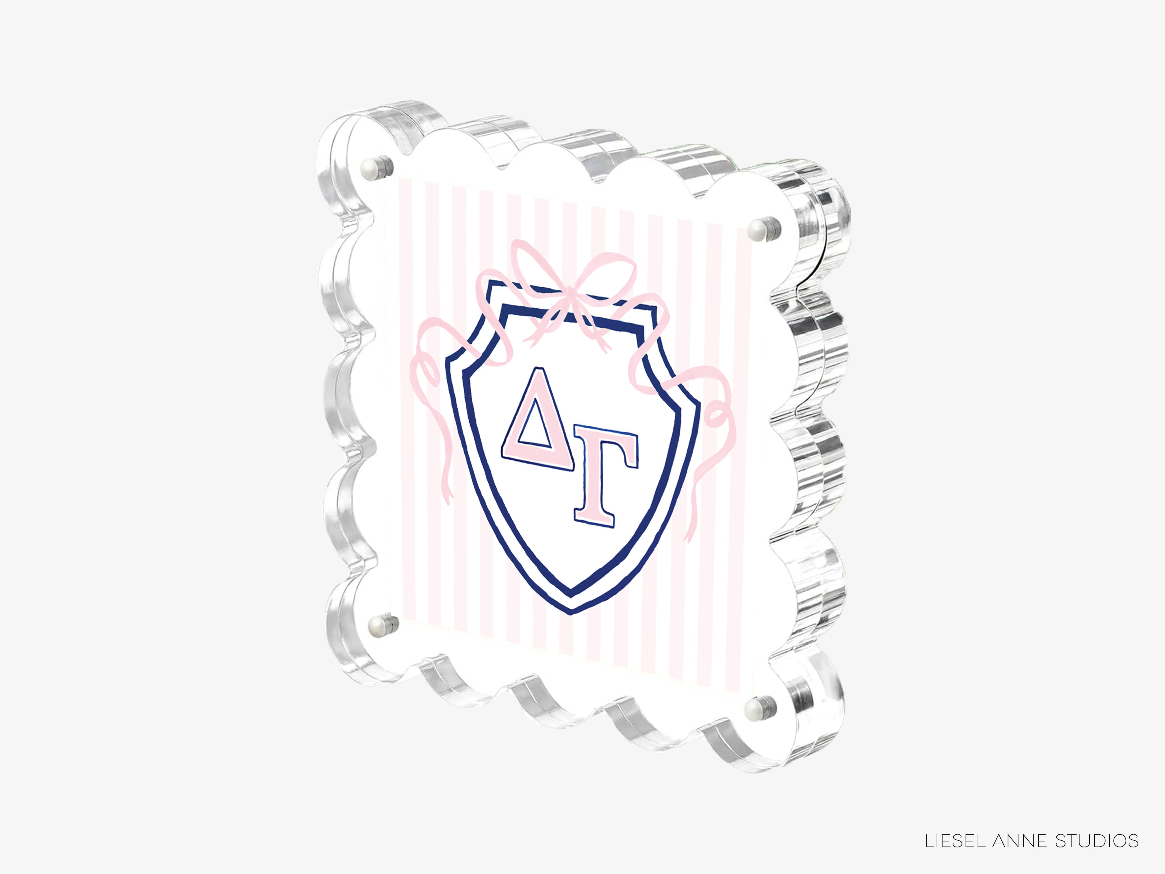 A 3D printed object with a shield-shaped design and a pink ribbon around it.