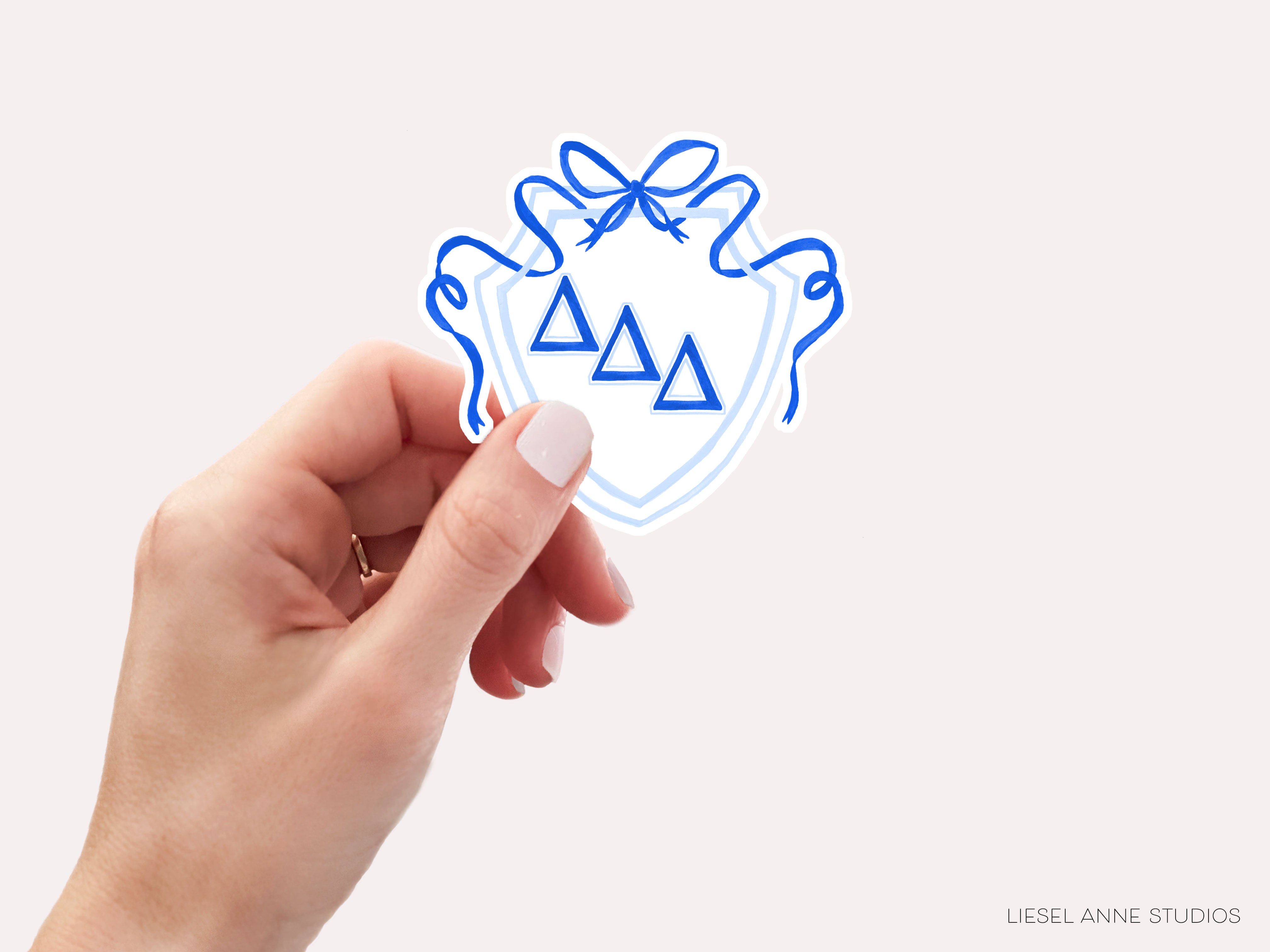 a hand holding a sticker with a blue design on it