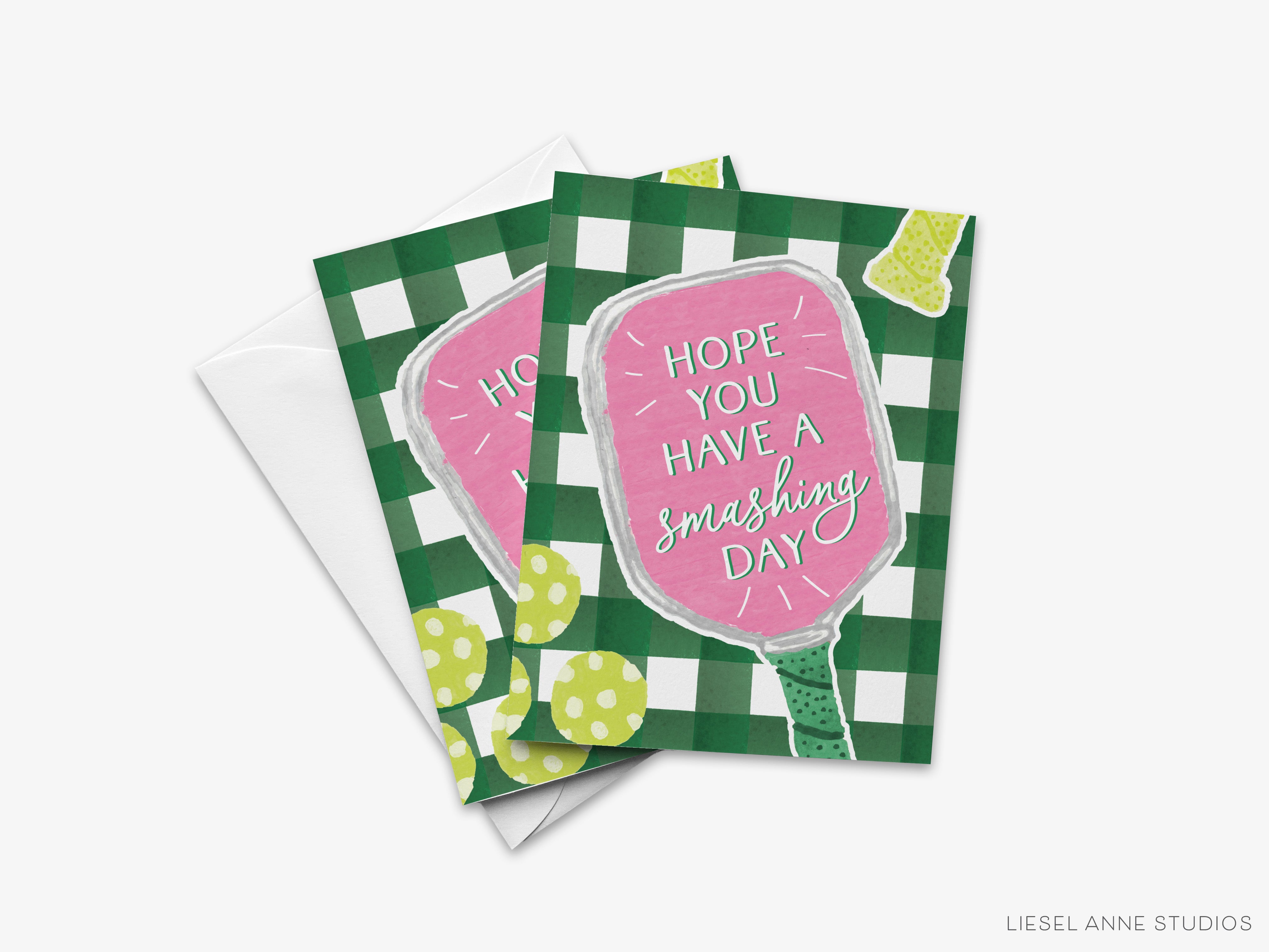 The image is a greeting card with a pink background and a green and white checkered pattern. The card has a message that says "Hope you have a smashing day" and features a pink paddle with a green handle.