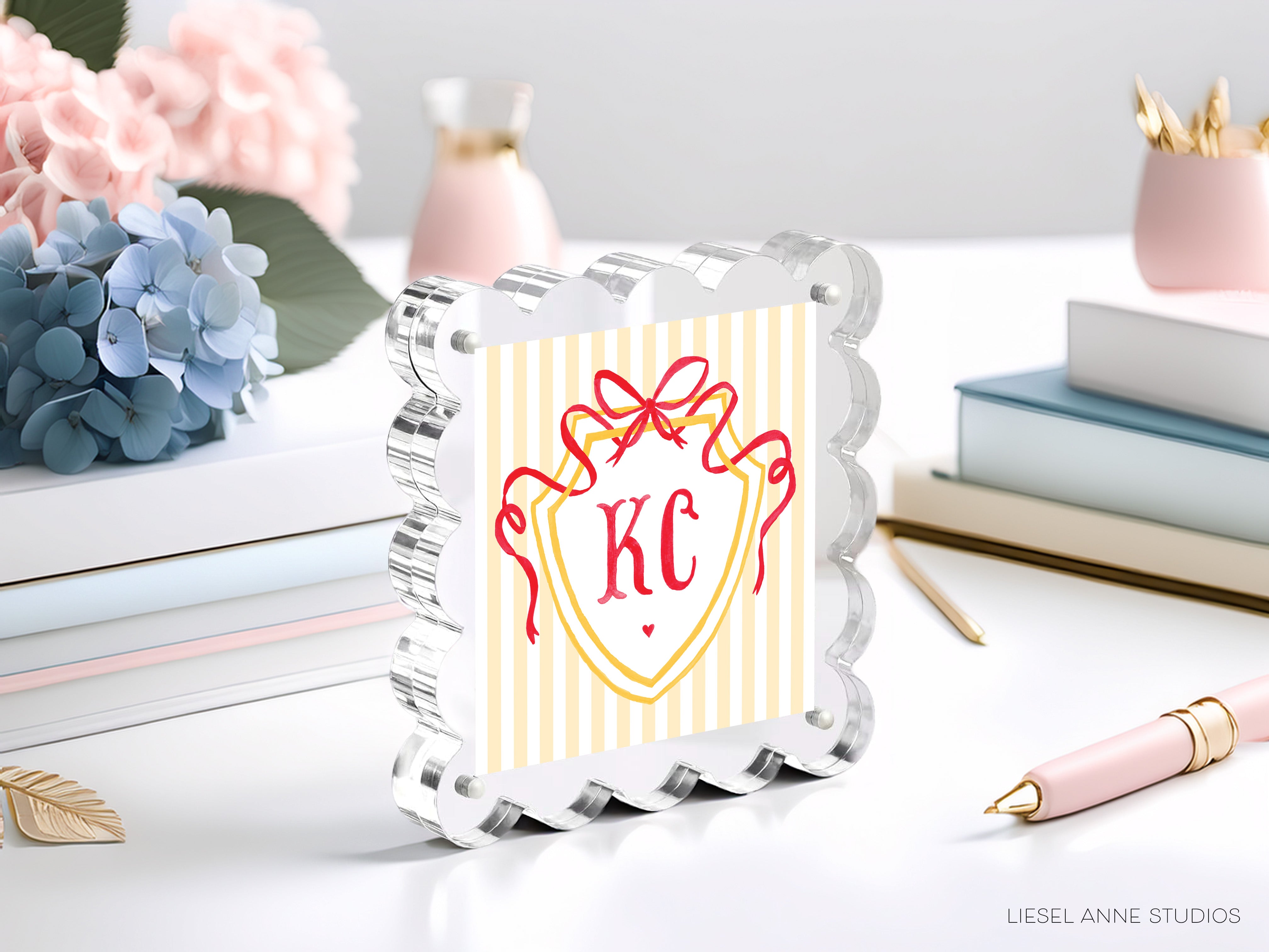 a decorative glass frame with a shield-shaped design, surrounded by various office supplies and decorative items such as flowers and books.