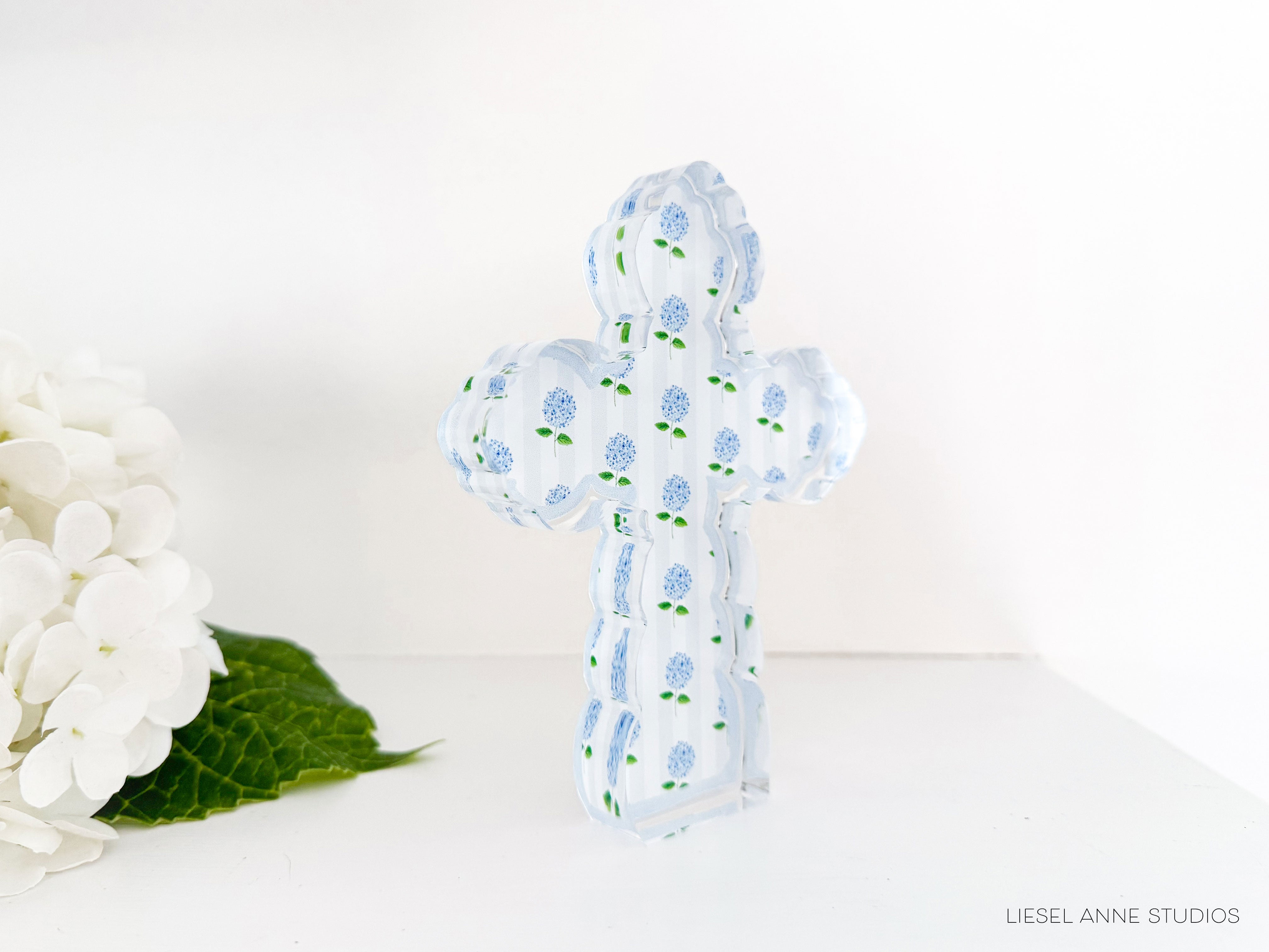 a white flower next to a blue and white cross