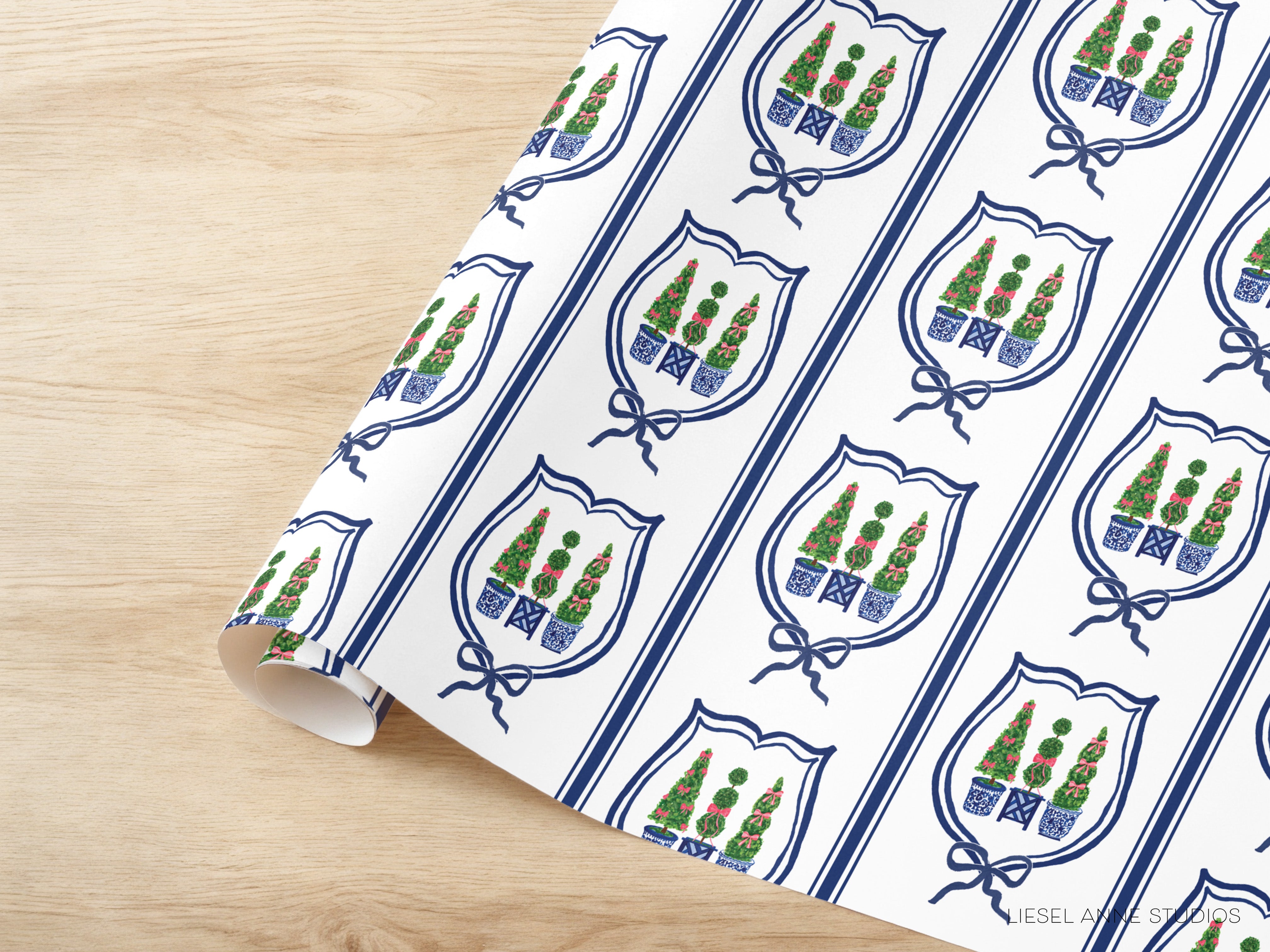 a repeating pattern of shield-shaped designs with green trees and blue ribbons on a white background.
