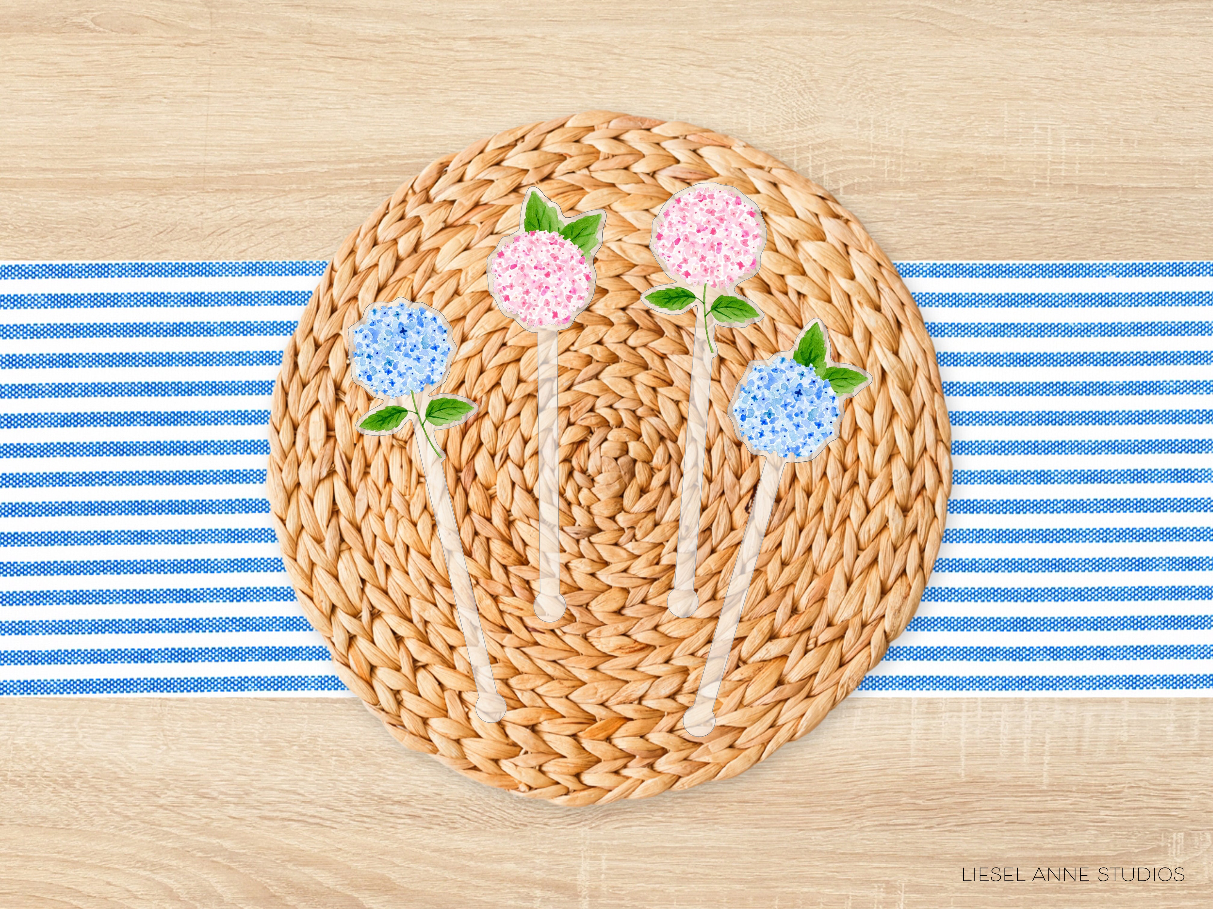 A woven placemat with a blue and white striped tablecloth underneath, featuring four small flower-shaped decorations in shades of pink and blue.