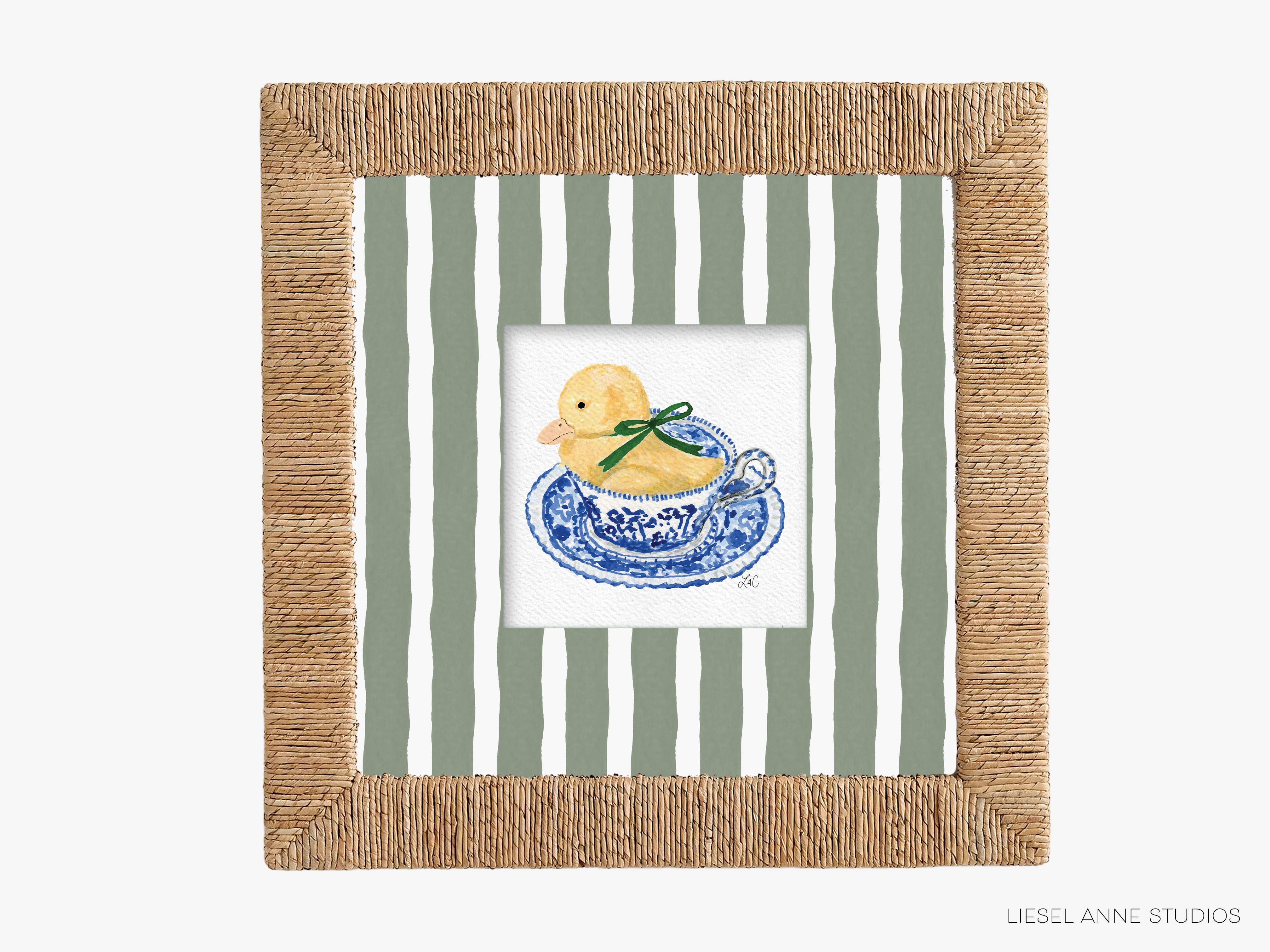 A framed image of a yellow duck sitting in a blue and white teacup, set against a striped green and white background.
