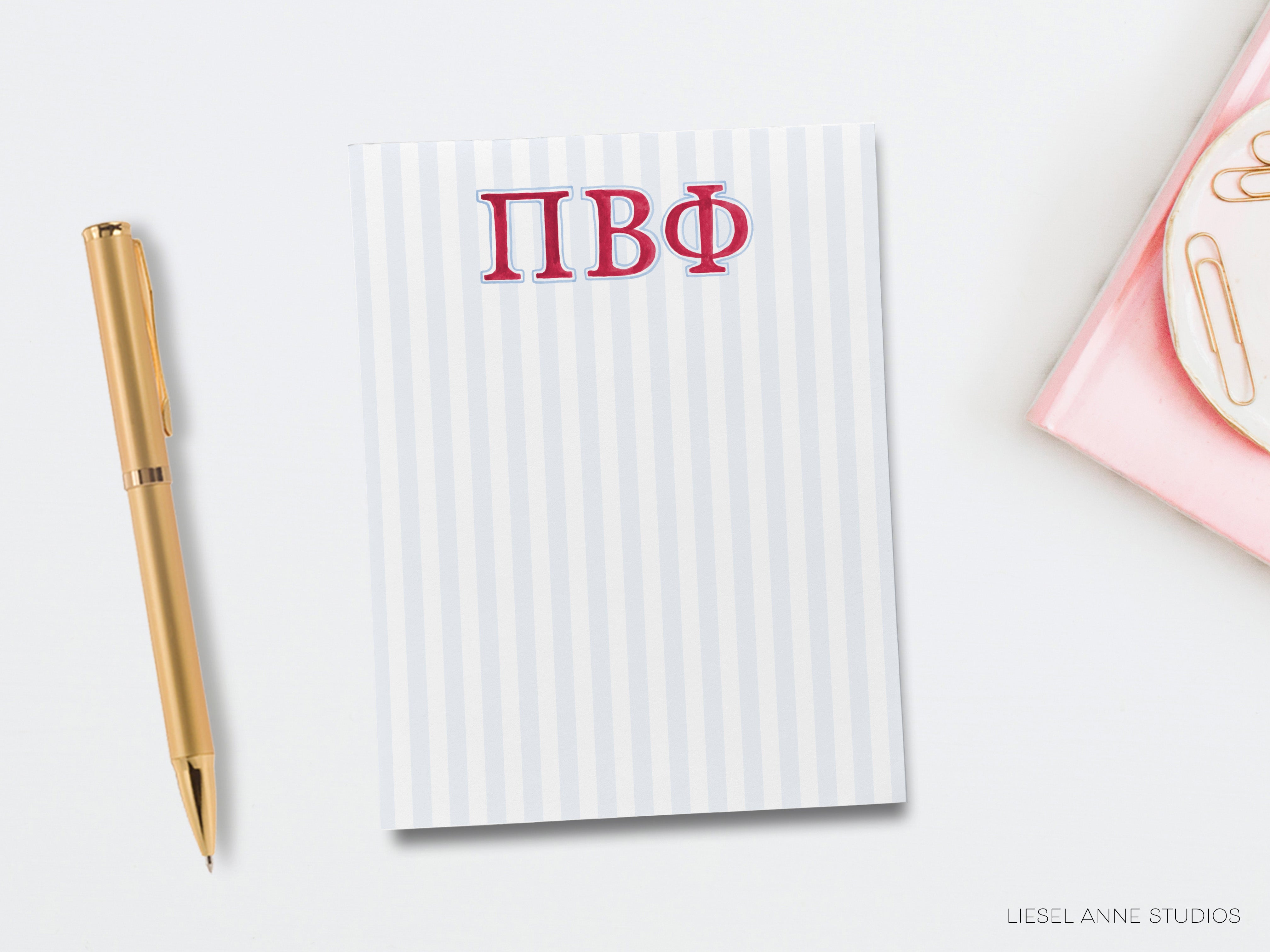 a notepad with a monogram on it next to a pen