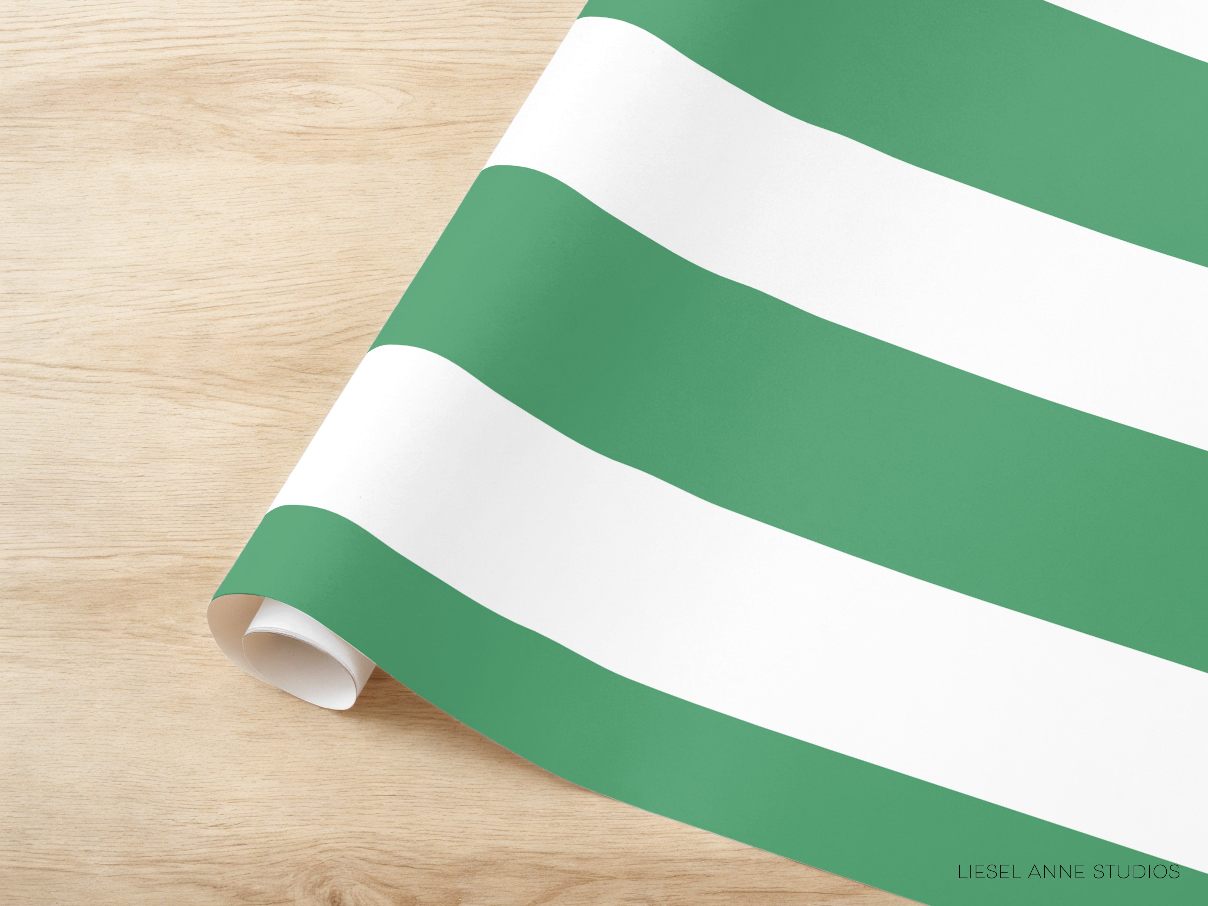 A roll of green and white striped paper is placed on a wooden surface.