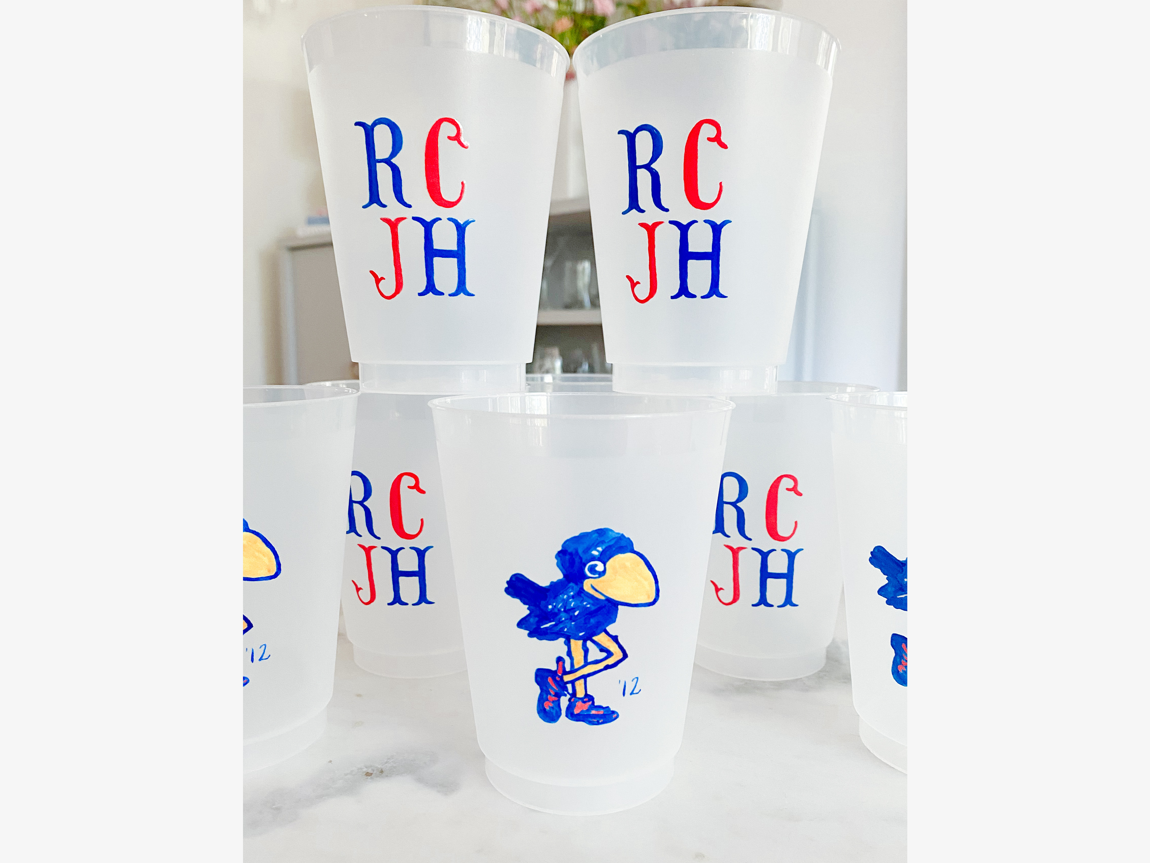 a collection of white plastic cups with blue and red text and illustrations.