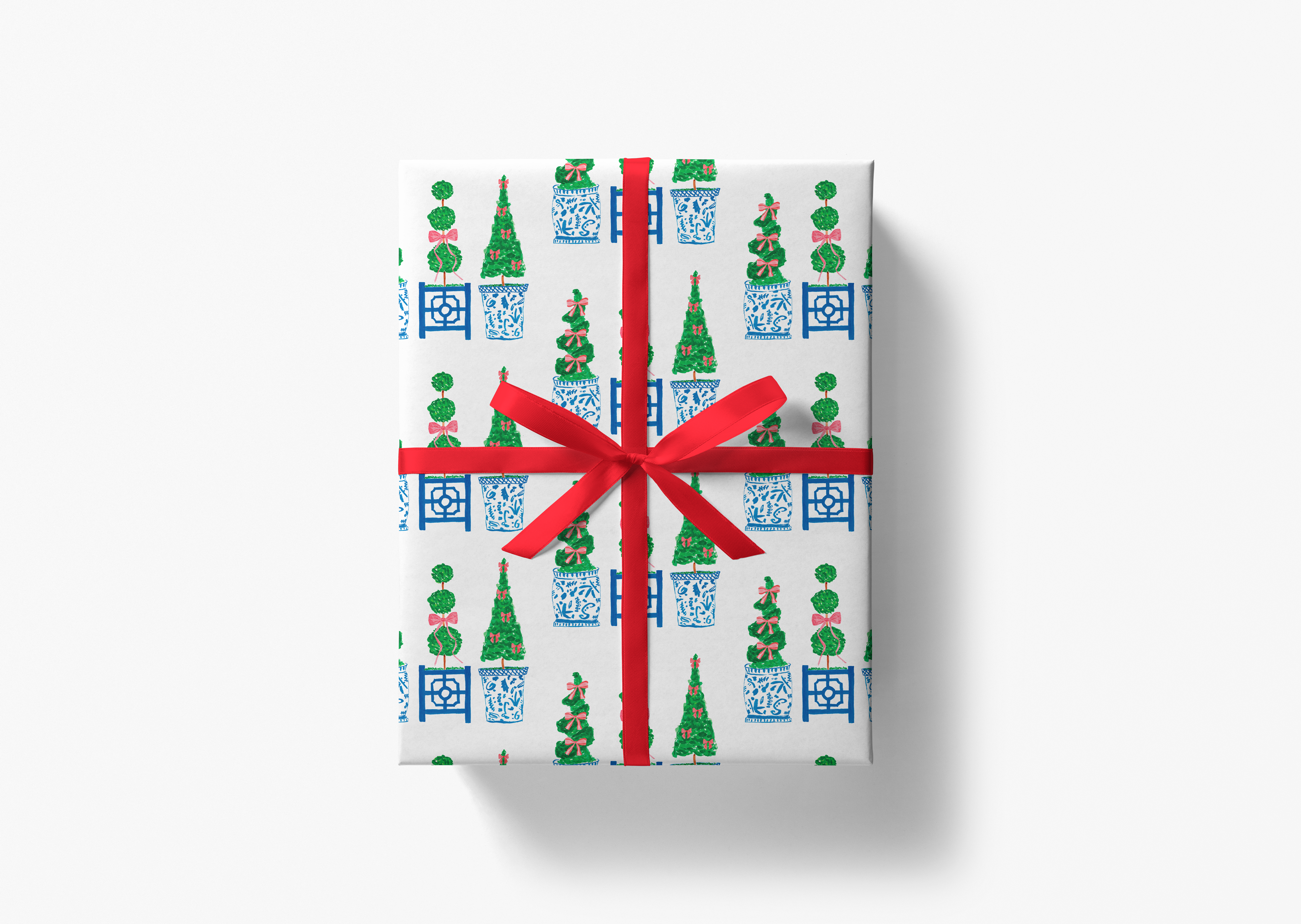 The image is a gift box with a red ribbon tied around it, decorated with a repeating pattern of Christmas trees and blue and white porcelain vases.