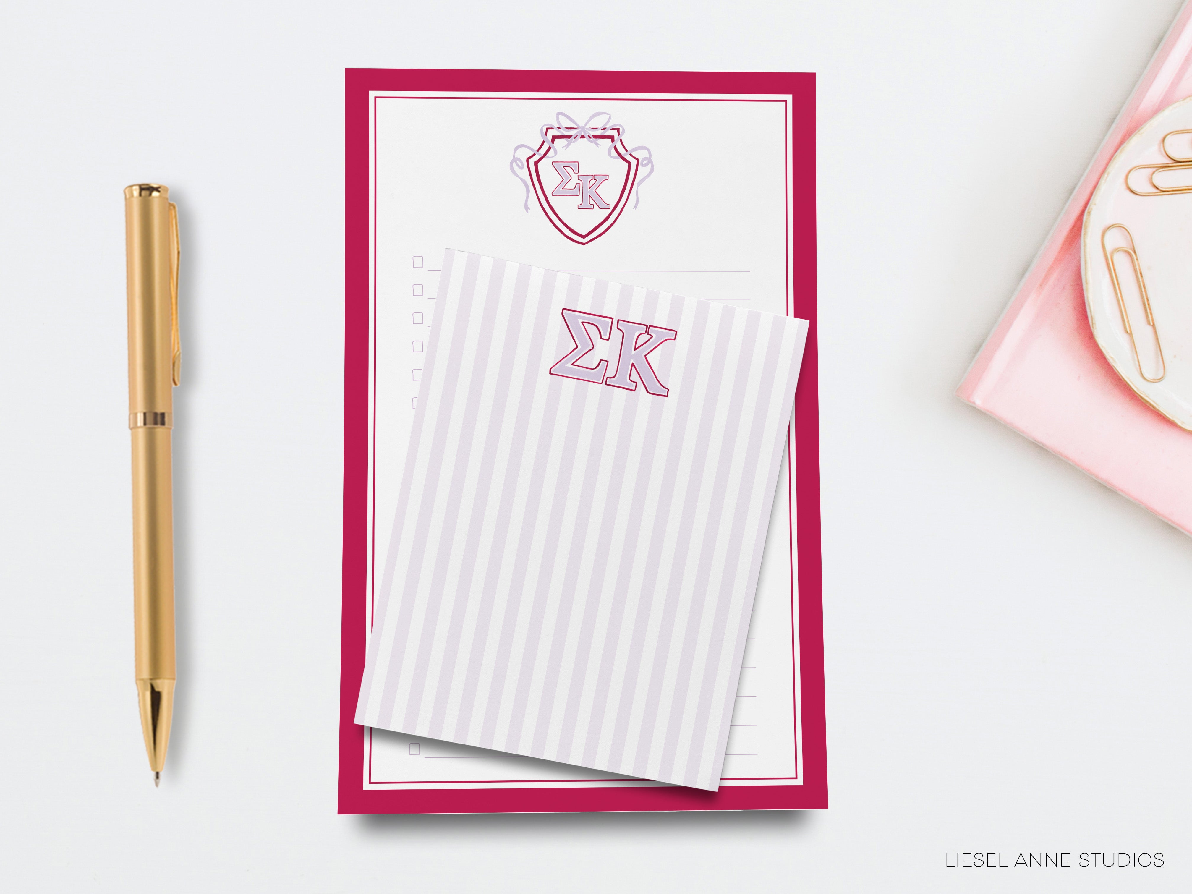 a desk with a notepad, pen, and envelope