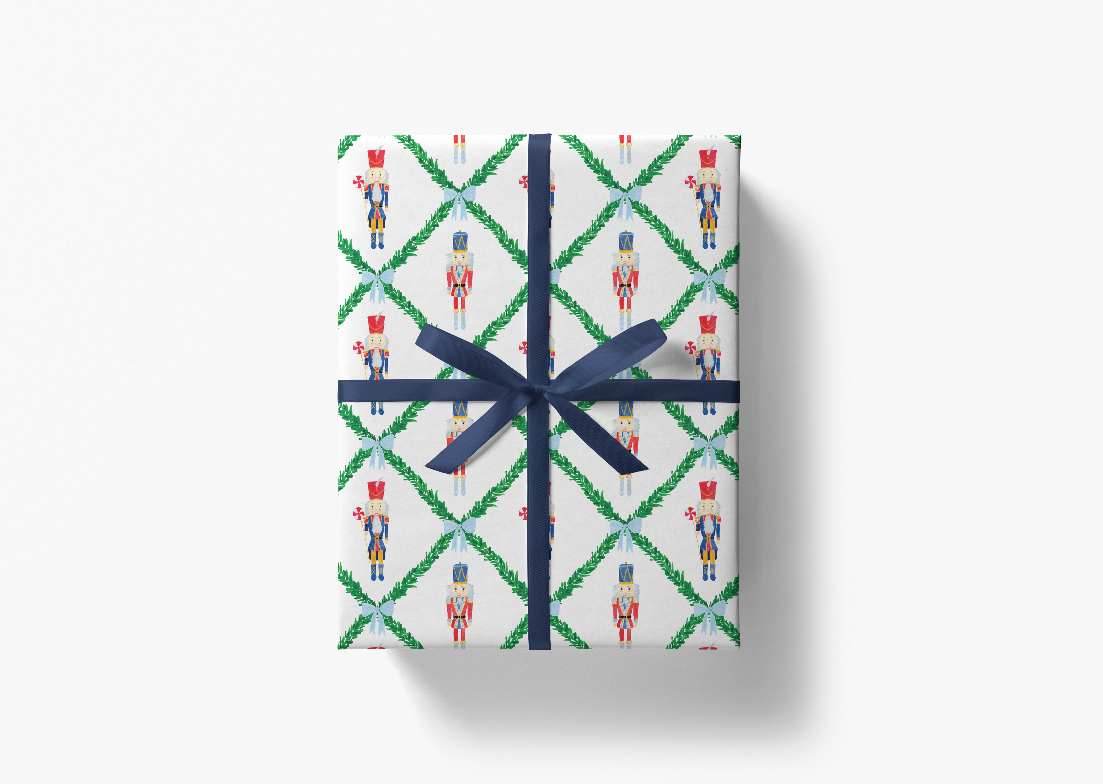 A gift box wrapped in a pattern of nutcracker characters on a white background, tied with a blue ribbon.