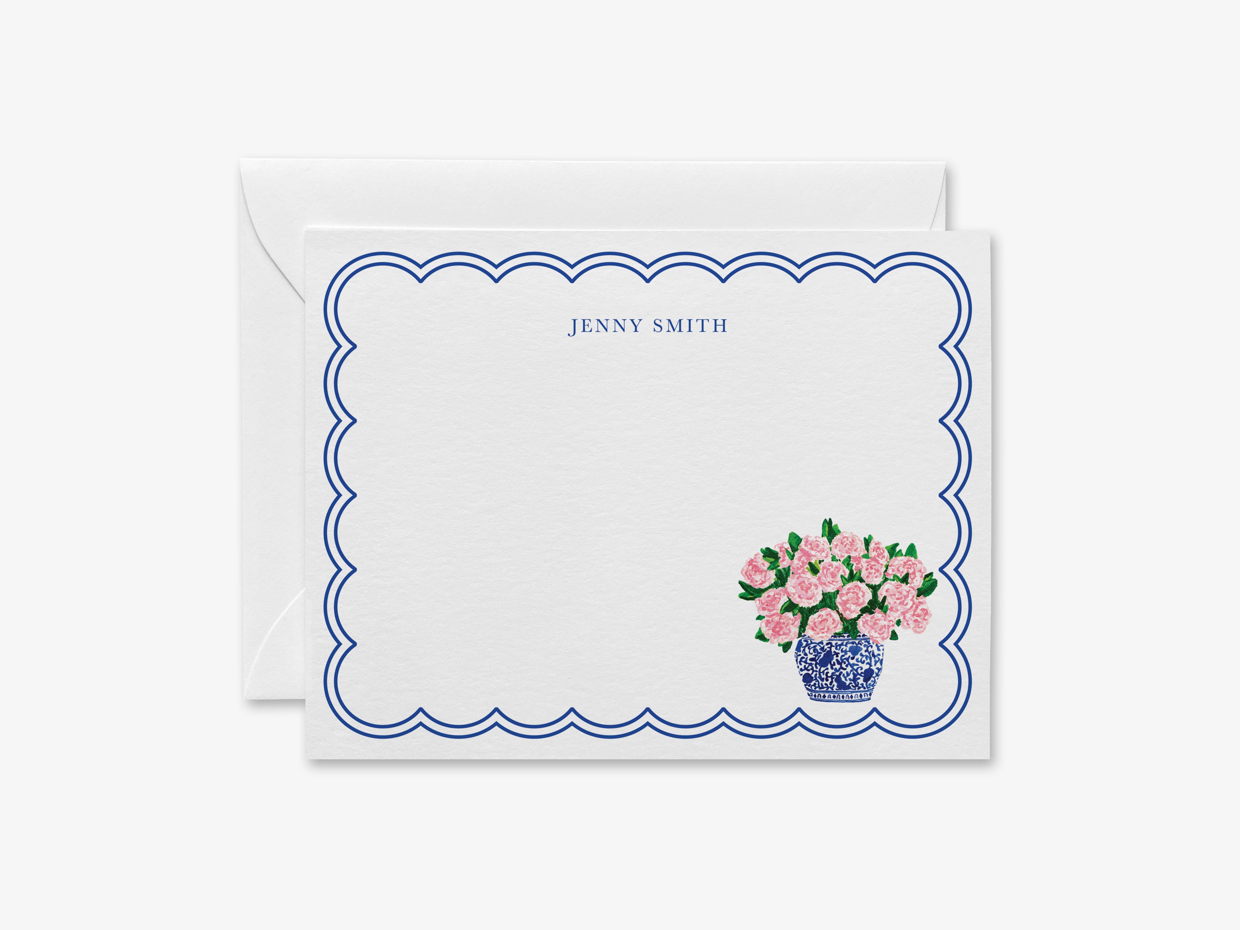 a white card with a scalloped edge and a blue border, containing a floral design and the name "Jenny Smith" written in blue text.