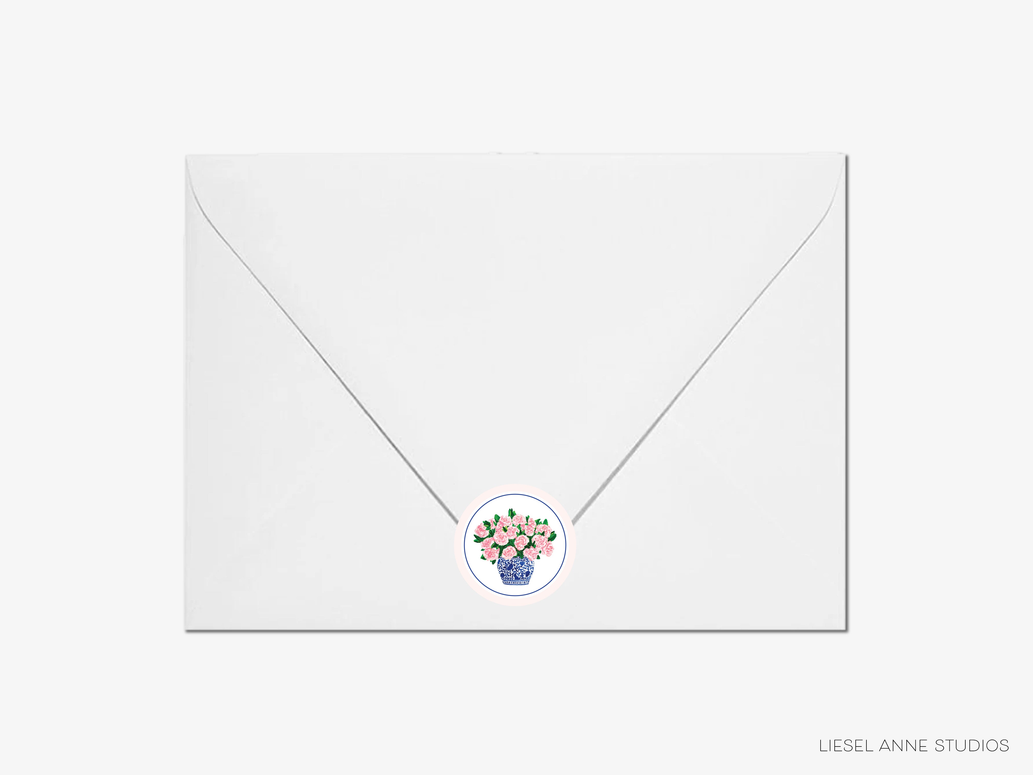 A white envelope with a floral sticker on it.
