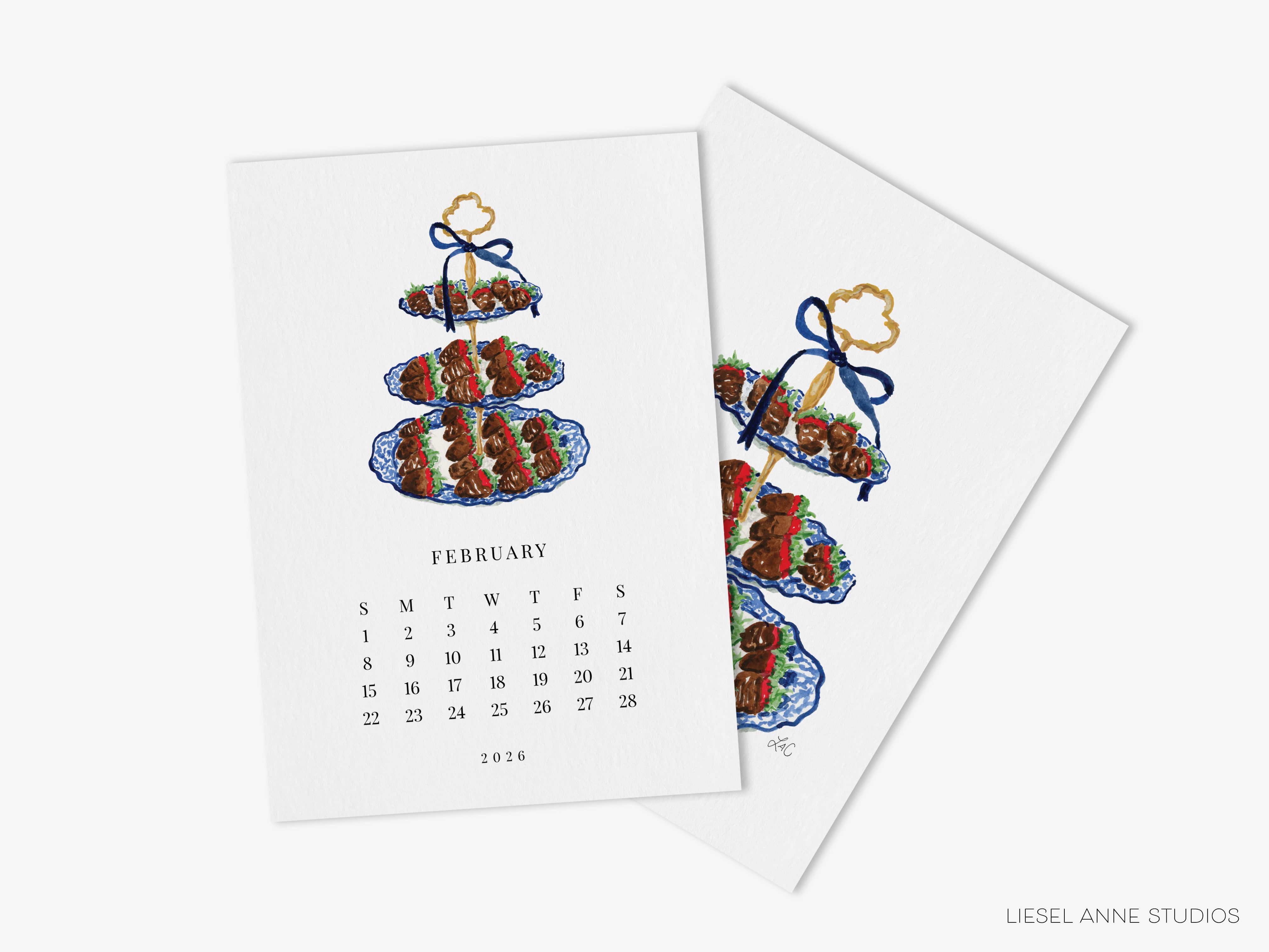 The image is a calendar for February of the year 2026, featuring a three-tiered cake design with a blue ribbon and a gold bow.