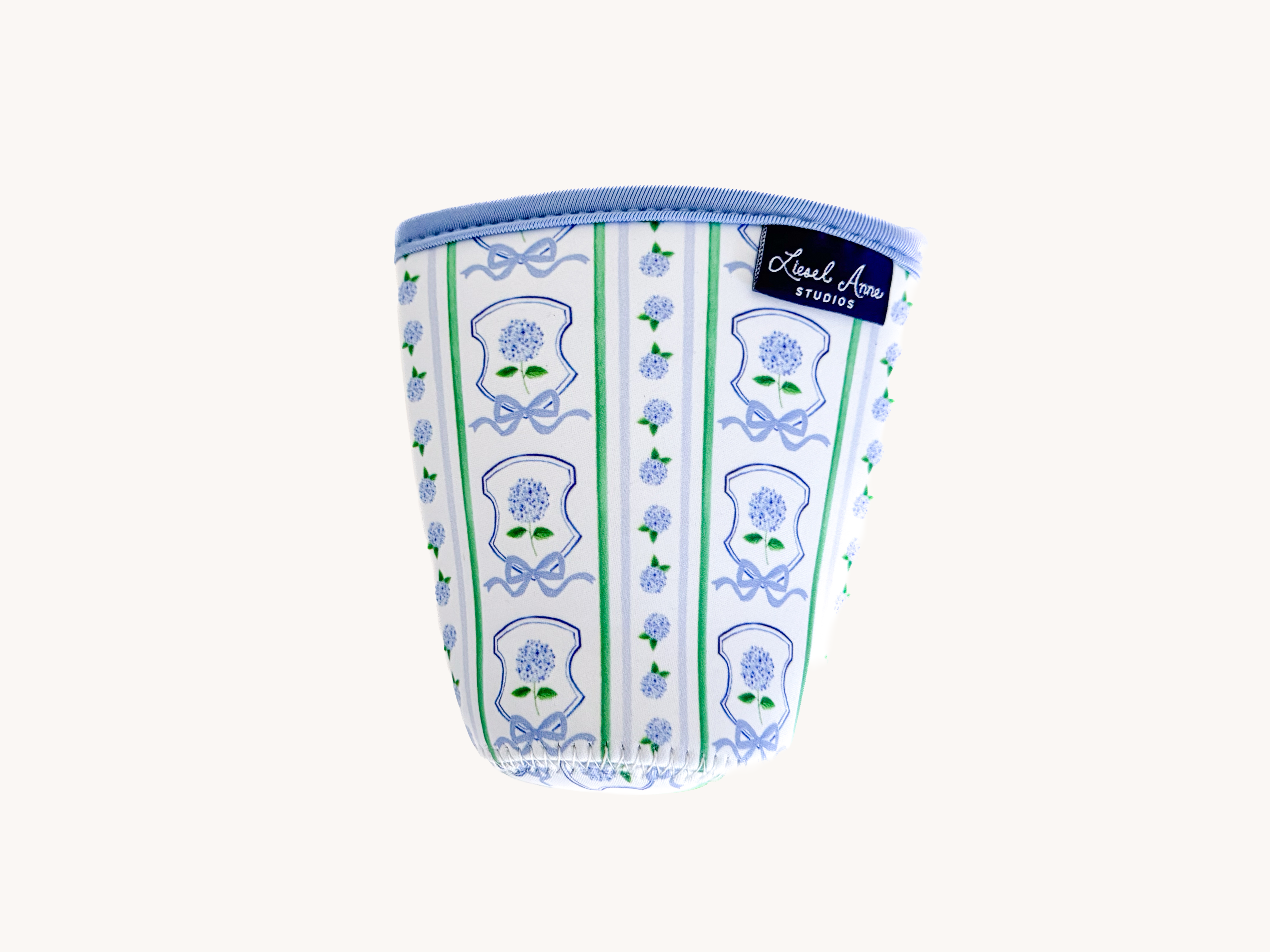 A white cup with a blue and green floral pattern printed on it.