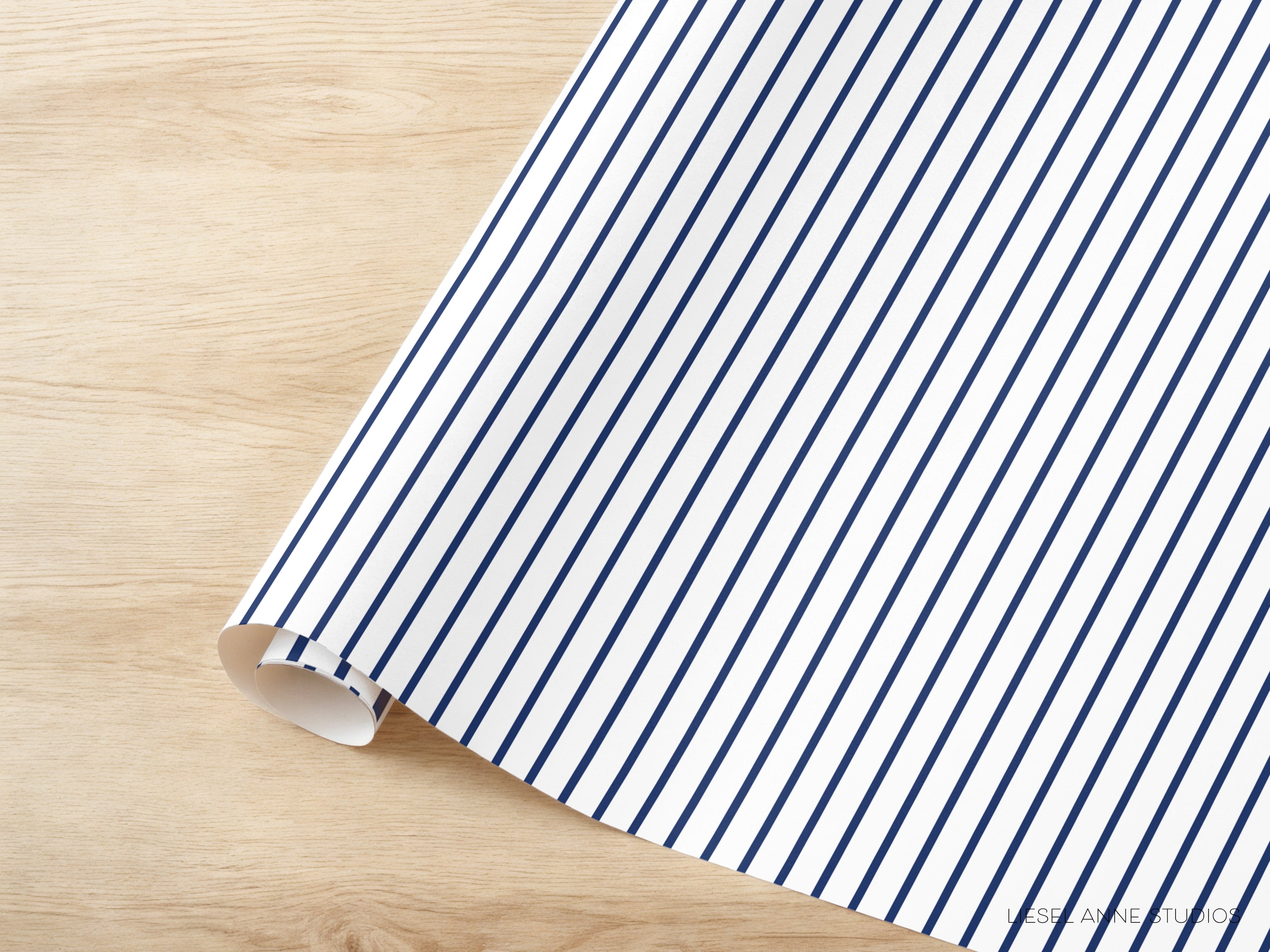 A roll of blue and white striped paper is placed on a wooden surface.