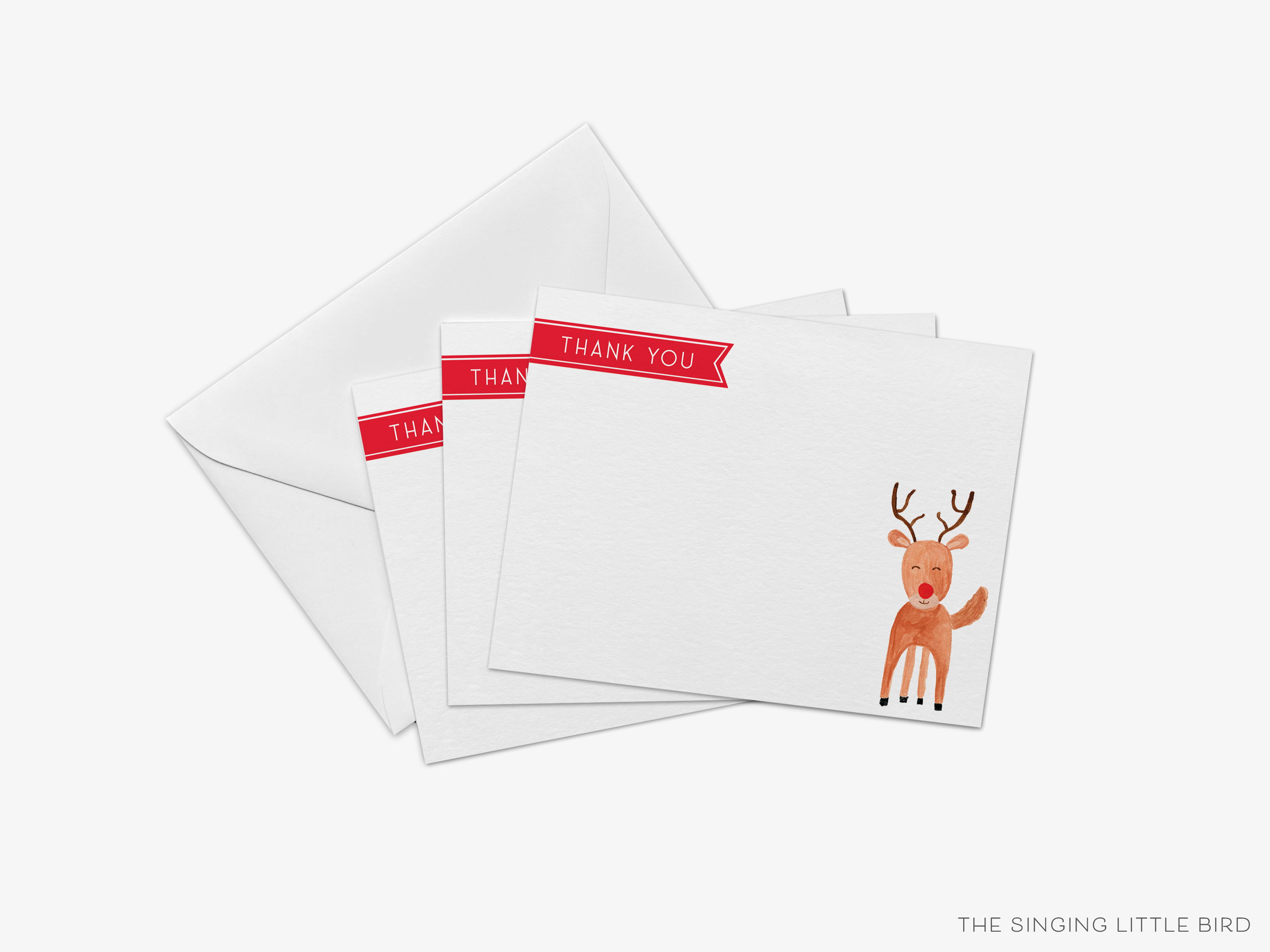 a set of white greeting cards with a red ribbon and a reindeer illustration.