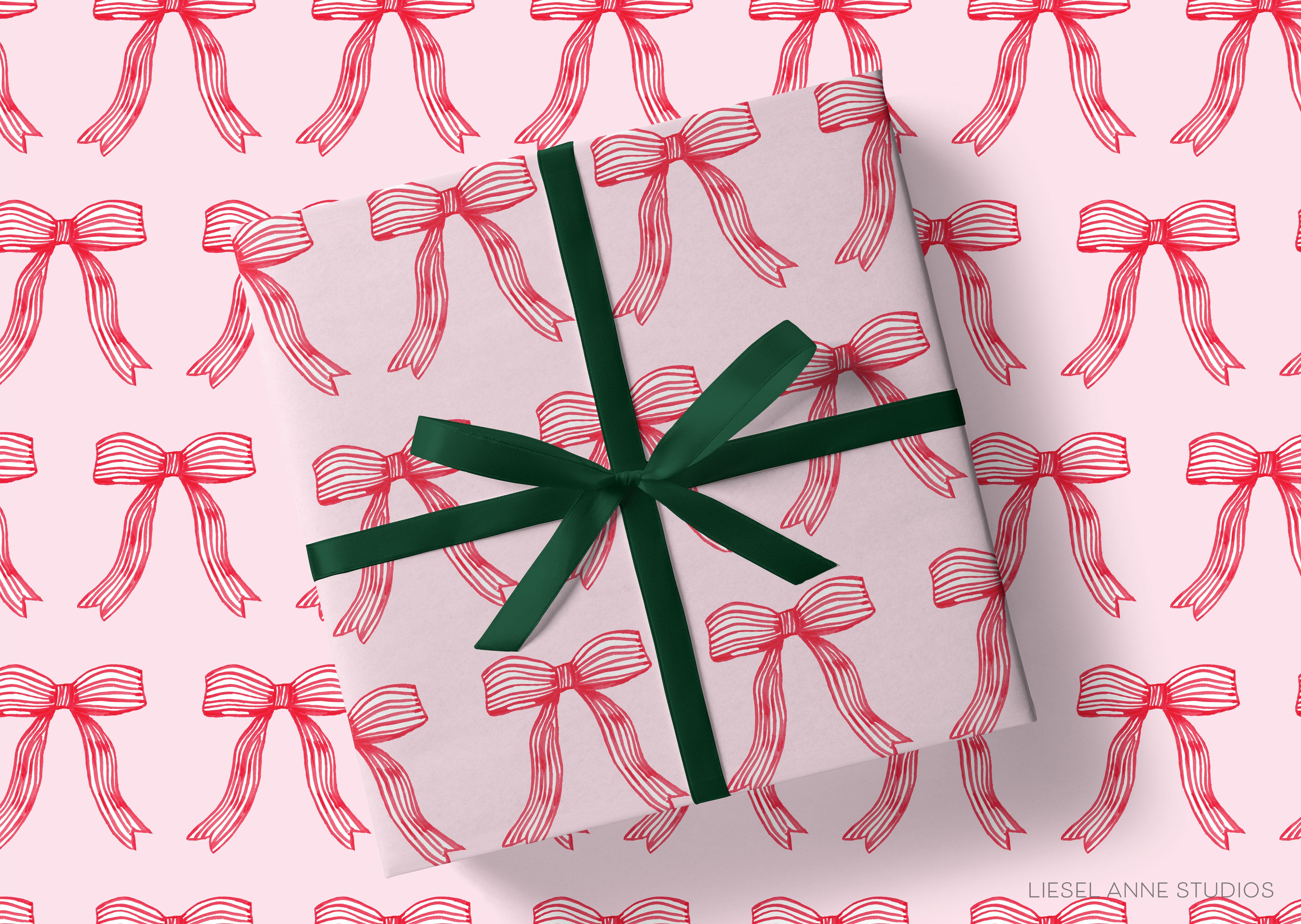 a gift wrapped in a white paper with a green ribbon, and the paper has a repeating pattern of red bows on it.