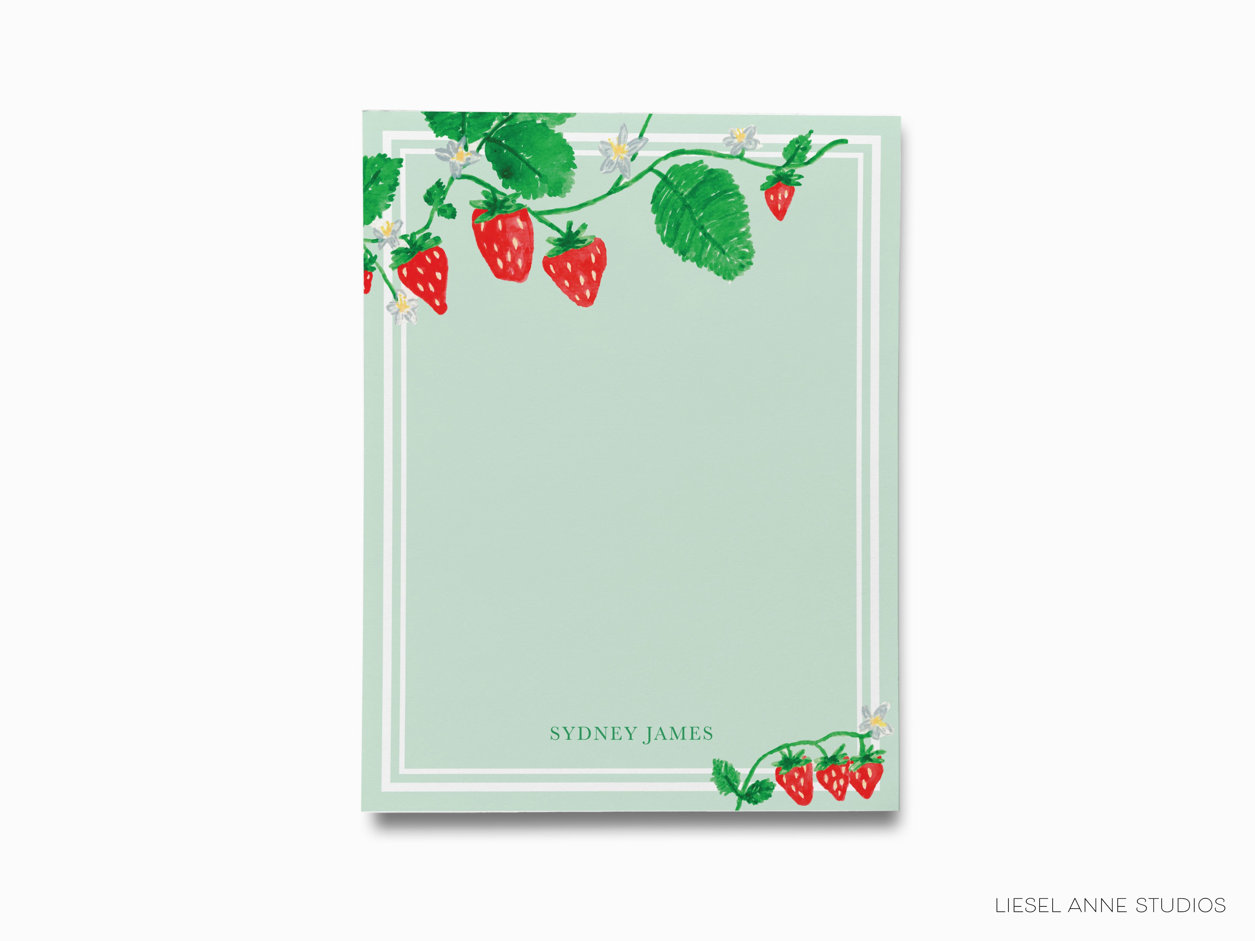a notepad with strawberries and leaves on it