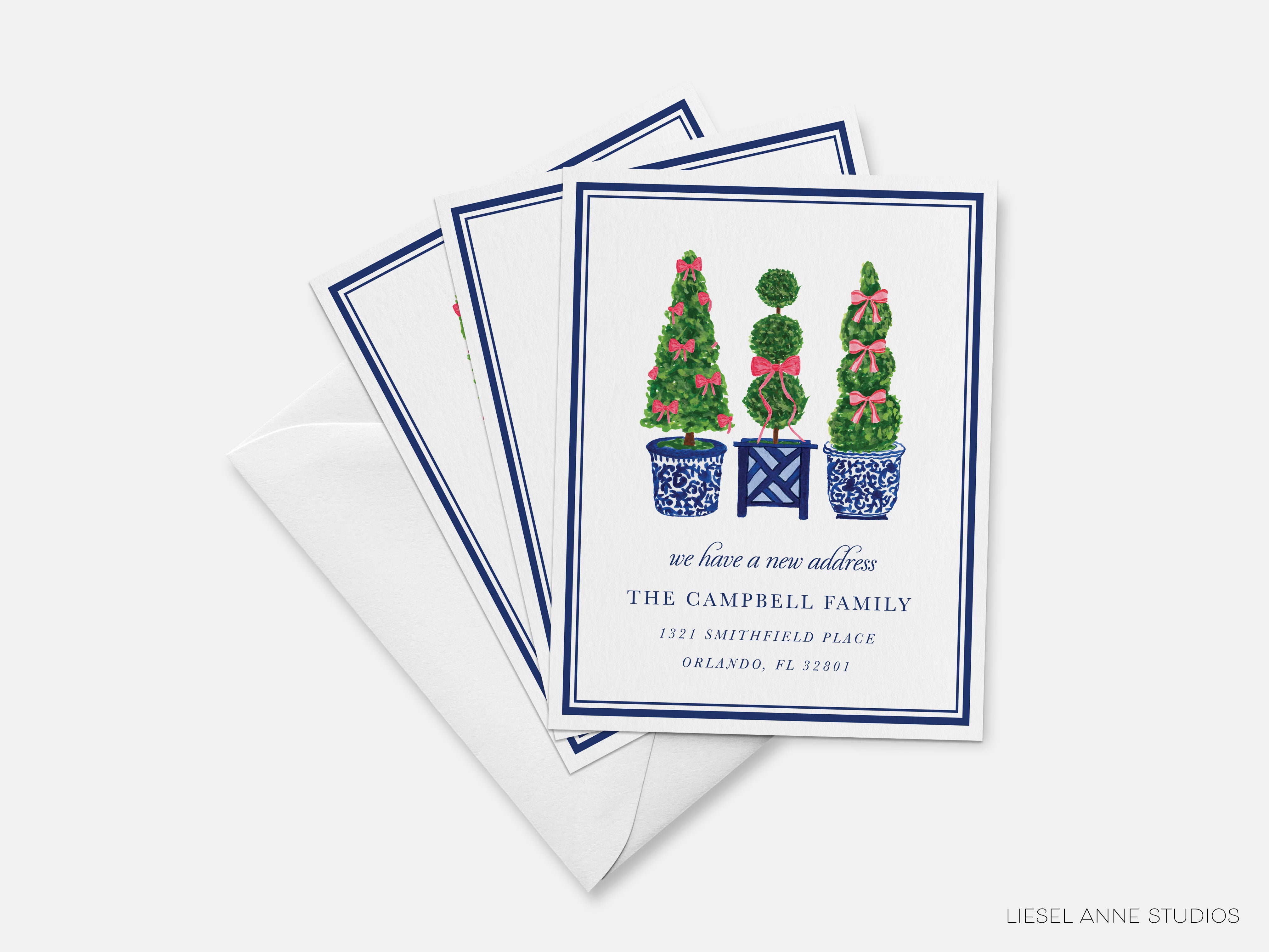 A set of three greeting cards with a design featuring three topiary trees in blue pots, along with a message about a new address.