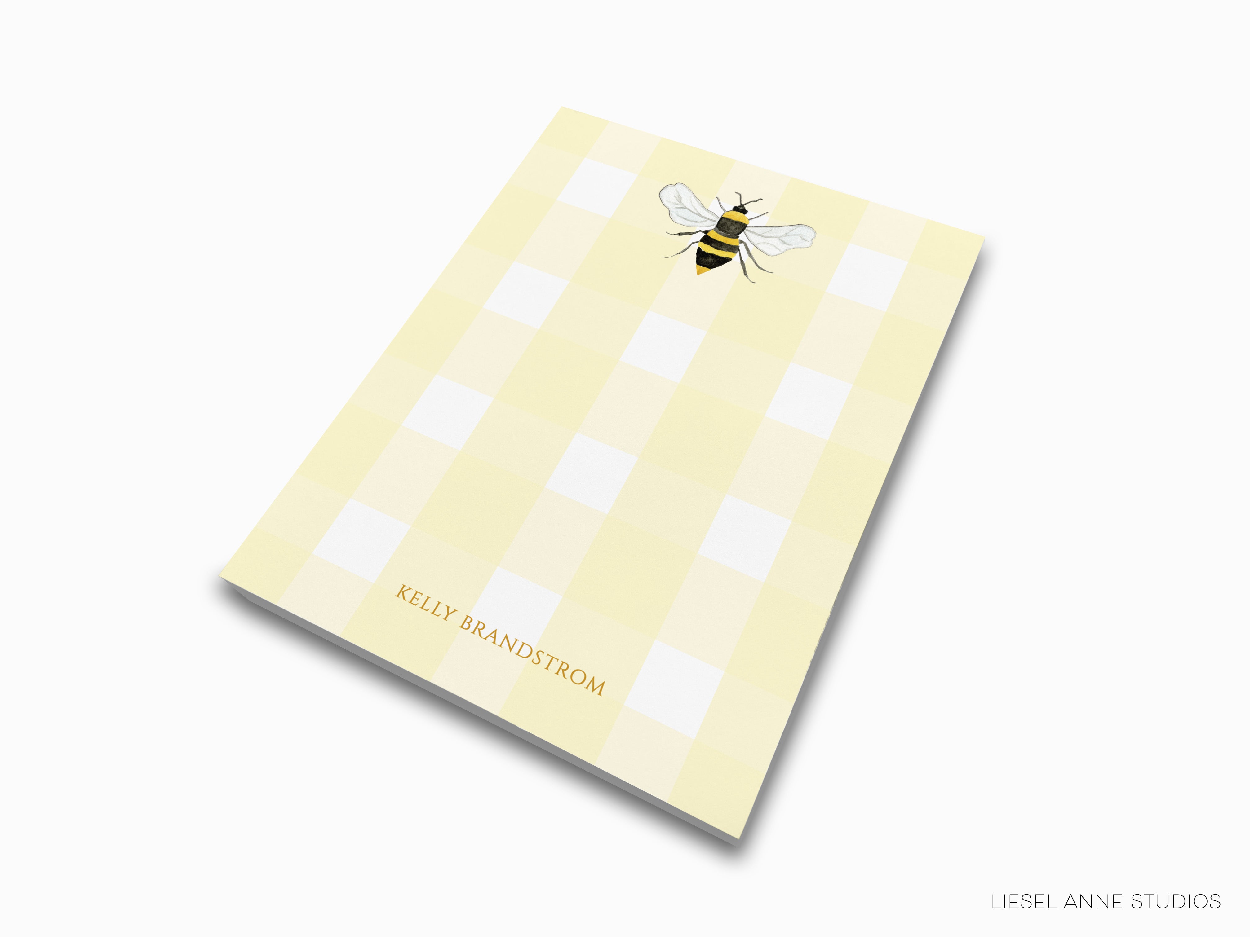 A yellow square with a bee illustration on it, and the text "KELLY BRANDSTROM" printed below.