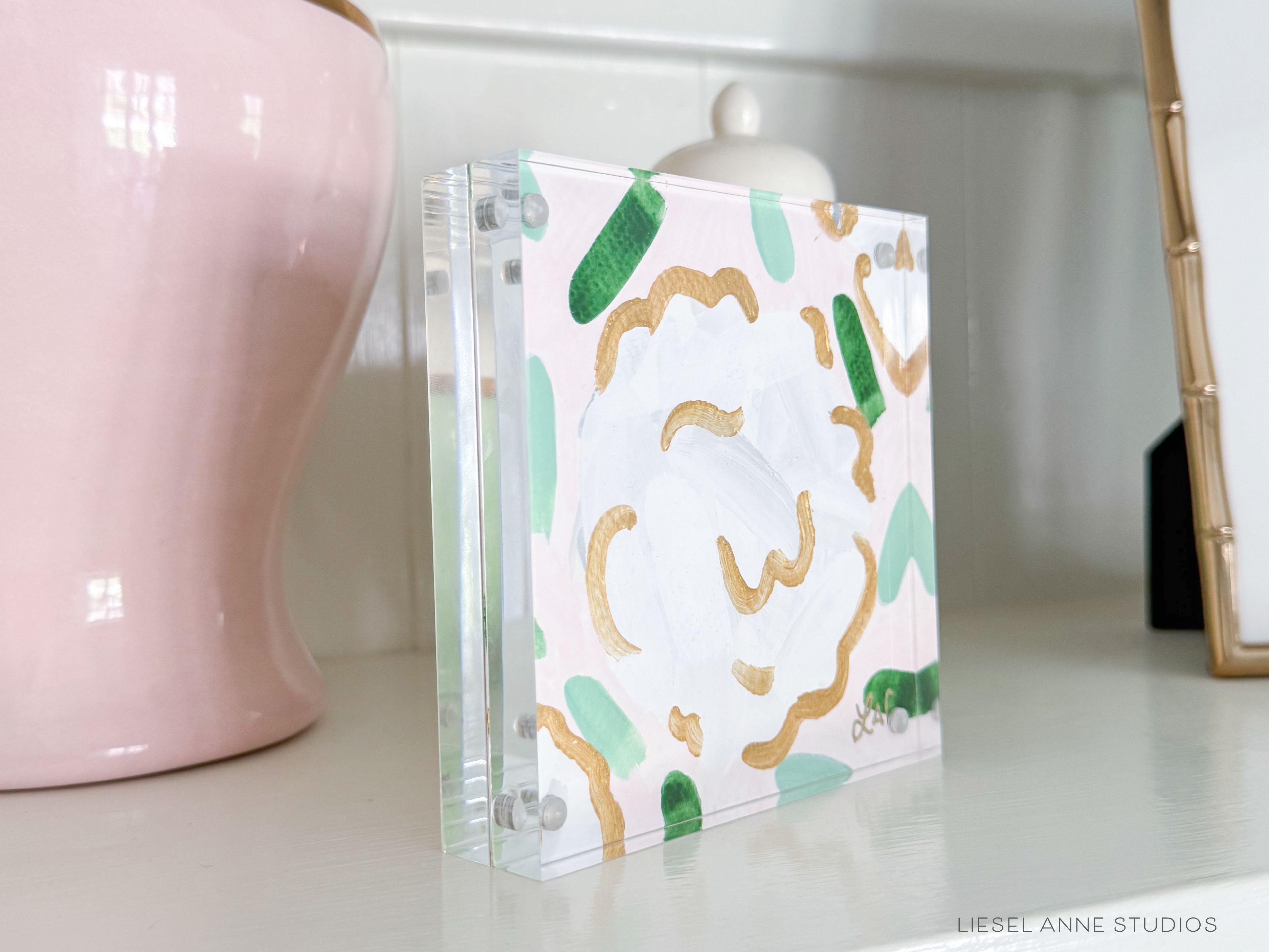 Golden Hydrangea Mini | Blush & White XXIV-Original artwork measures 5"x5" | Hand-Painted with gouache on cold press watercolor paper | Matted and framed in gold wood frame sized 20"x20" | Glare-resistant glass | Hanging hardware included | Features our signature Golden Hydrangea design with a pale pink base, white hydrangeas and shimmery gold accents | Initialed in gold by the Liesel Anne (the artist) on the front and signed and dated on the back.-The Singing Little Bird