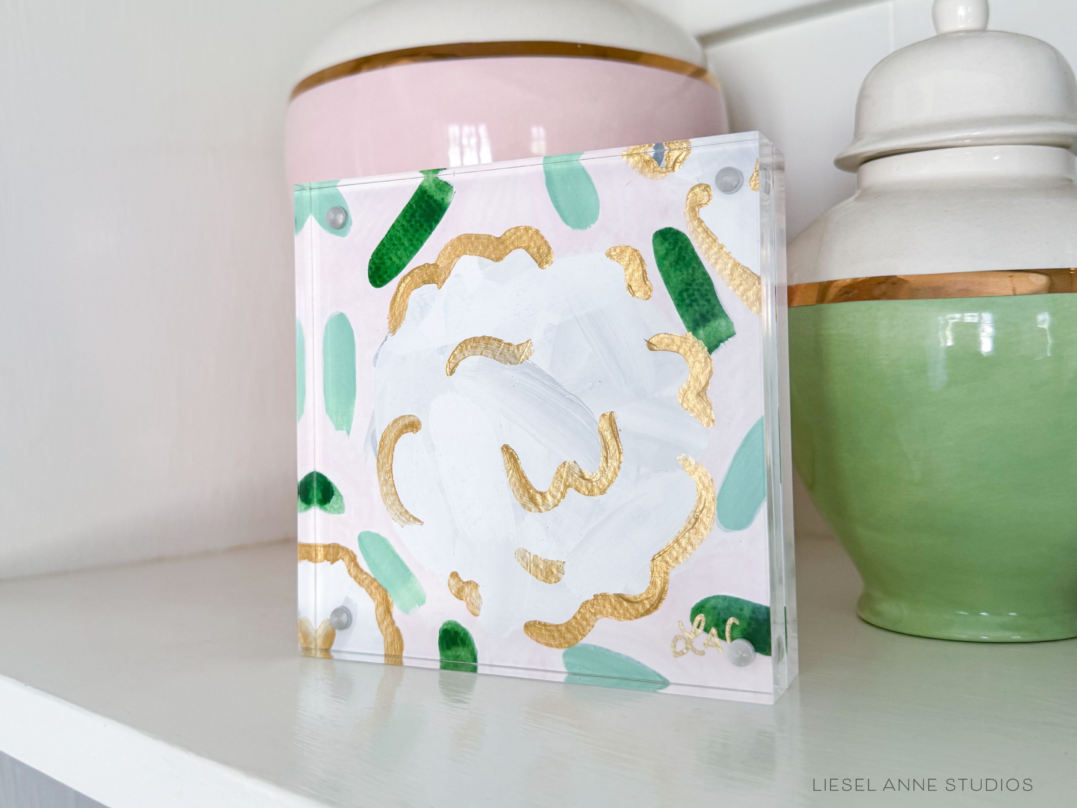 Golden Hydrangea Mini | Blush & White XXIV-Original artwork measures 5"x5" | Hand-Painted with gouache on cold press watercolor paper | Matted and framed in gold wood frame sized 20"x20" | Glare-resistant glass | Hanging hardware included | Features our signature Golden Hydrangea design with a pale pink base, white hydrangeas and shimmery gold accents | Initialed in gold by the Liesel Anne (the artist) on the front and signed and dated on the back.-The Singing Little Bird