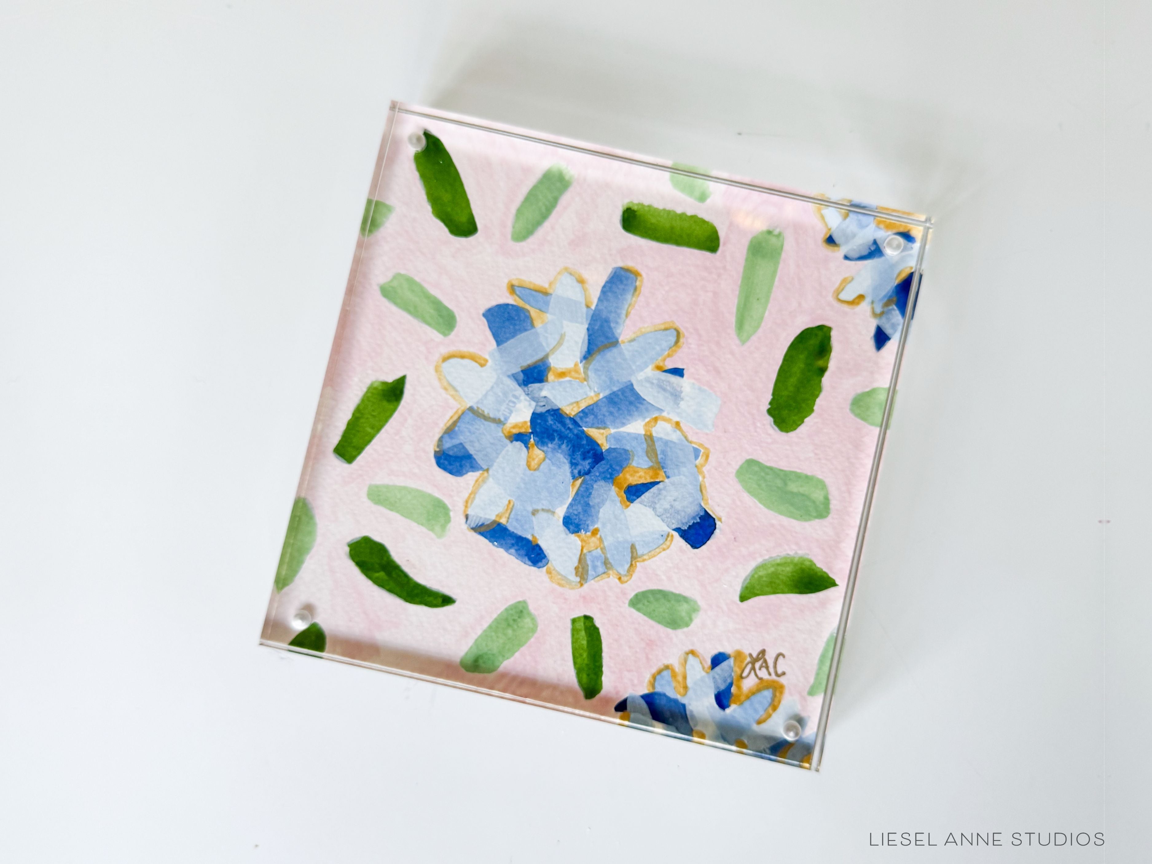 Golden Hydrangea Mini | Pink & Blue 03-Original artwork measures 6"x6" | Hand-Painted with gouache on cold press watercolor paper | Framed in clear acrylic magnetic block frame | Features our signature Golden Hydrangea design with a pale pink base, blue hydrangeas and shimmery gold accents | Initialed in gold by the Liesel Anne (the artist) on the front and signed and dated on the back-The Singing Little Bird