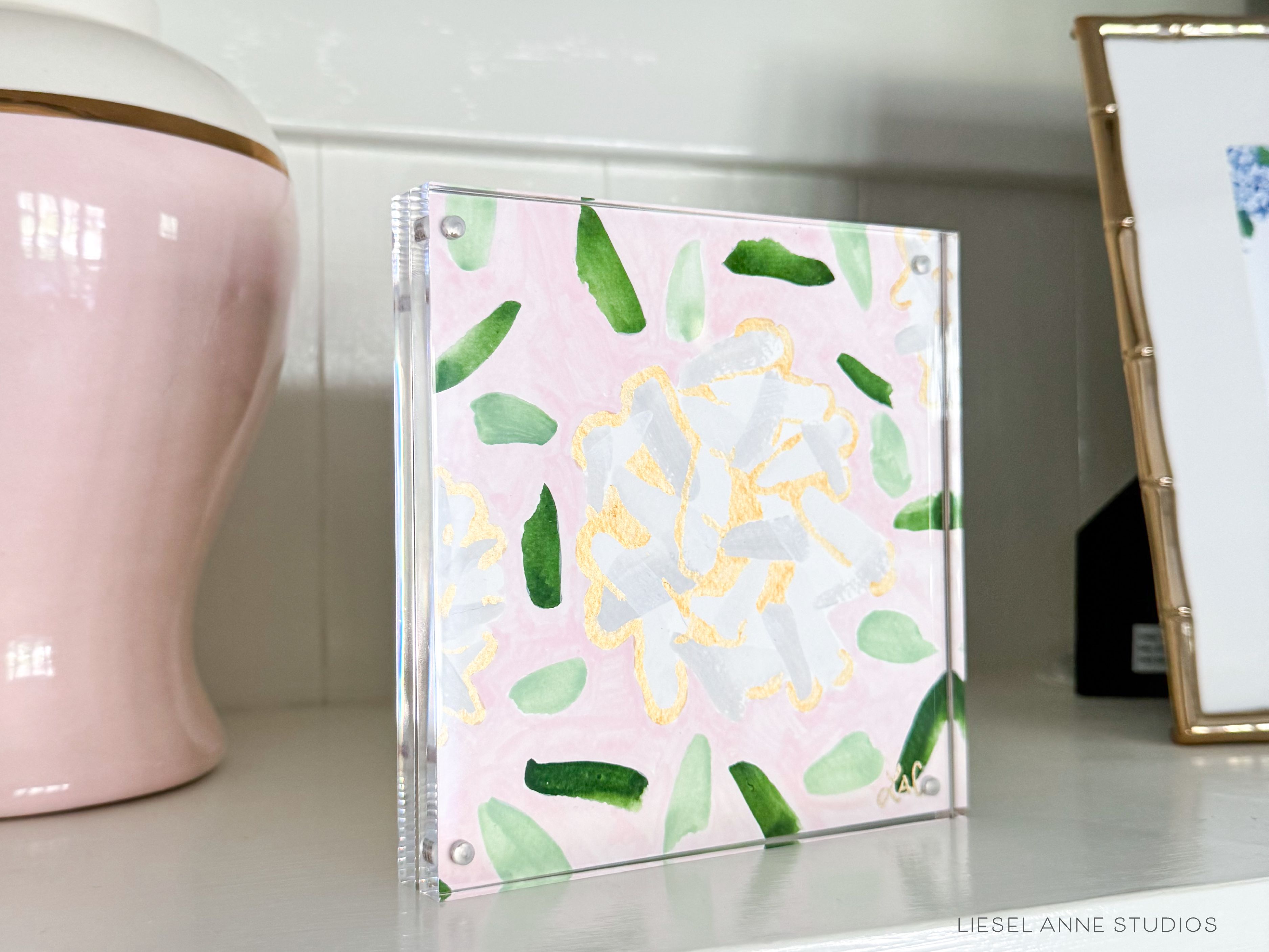Golden Hydrangea Mini | Pink & White 02-Original artwork measures 6"x6" | Hand-Painted with gouache on cold press watercolor paper | Framed in clear acrylic magnetic block frame | Features our signature Golden Hydrangea design with a pale pink base, white hydrangeas and shimmery gold accents | Initialed in gold by the Liesel Anne (the artist) on the front and signed and dated on the back-The Singing Little Bird