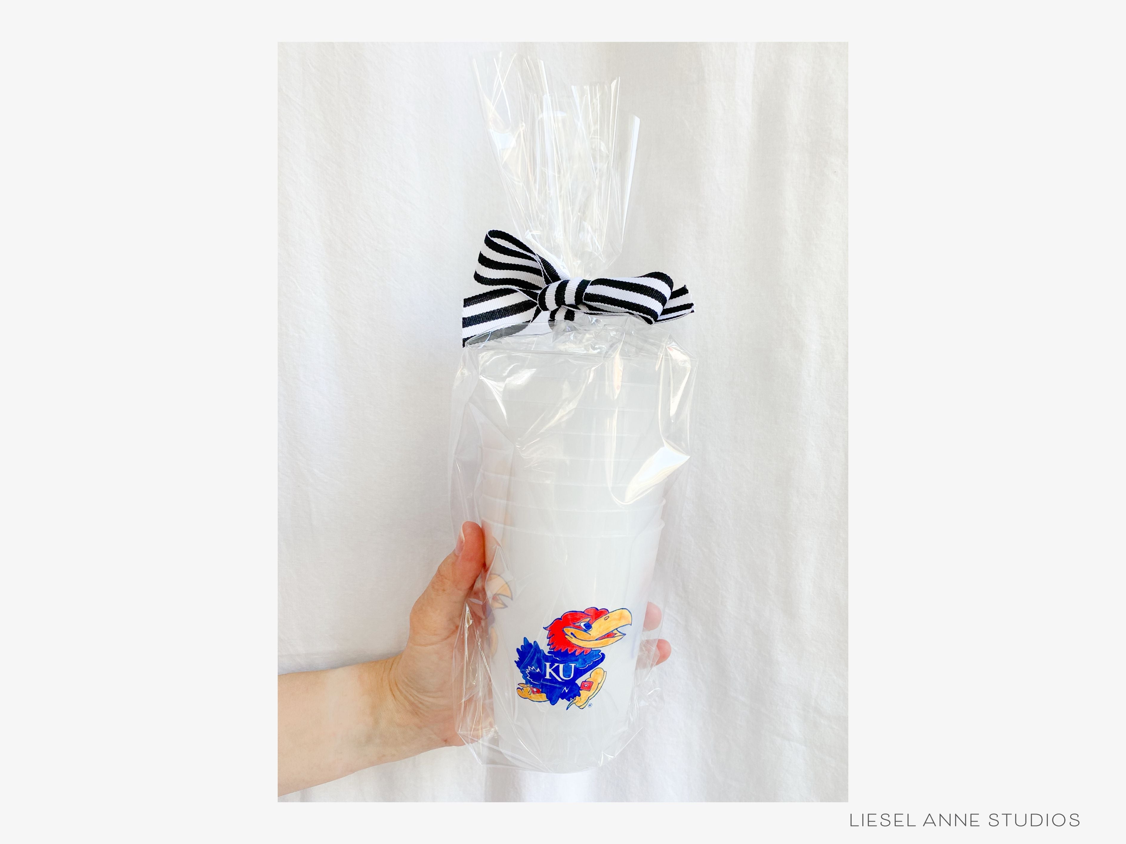 Jayhawk *Officially Licensed* 16oz Shatterproof Cups (Set of 8)-These officially licensed Kansas Jayhawk shatterproof cups feature our hand-painted Jayhawk and Rock Chalk text and make great party decorations for watch parties, graduation, game days and more! They come in sets of 8 and are re-usable for other parties to come or make wonderful party favors!-The Singing Little Bird