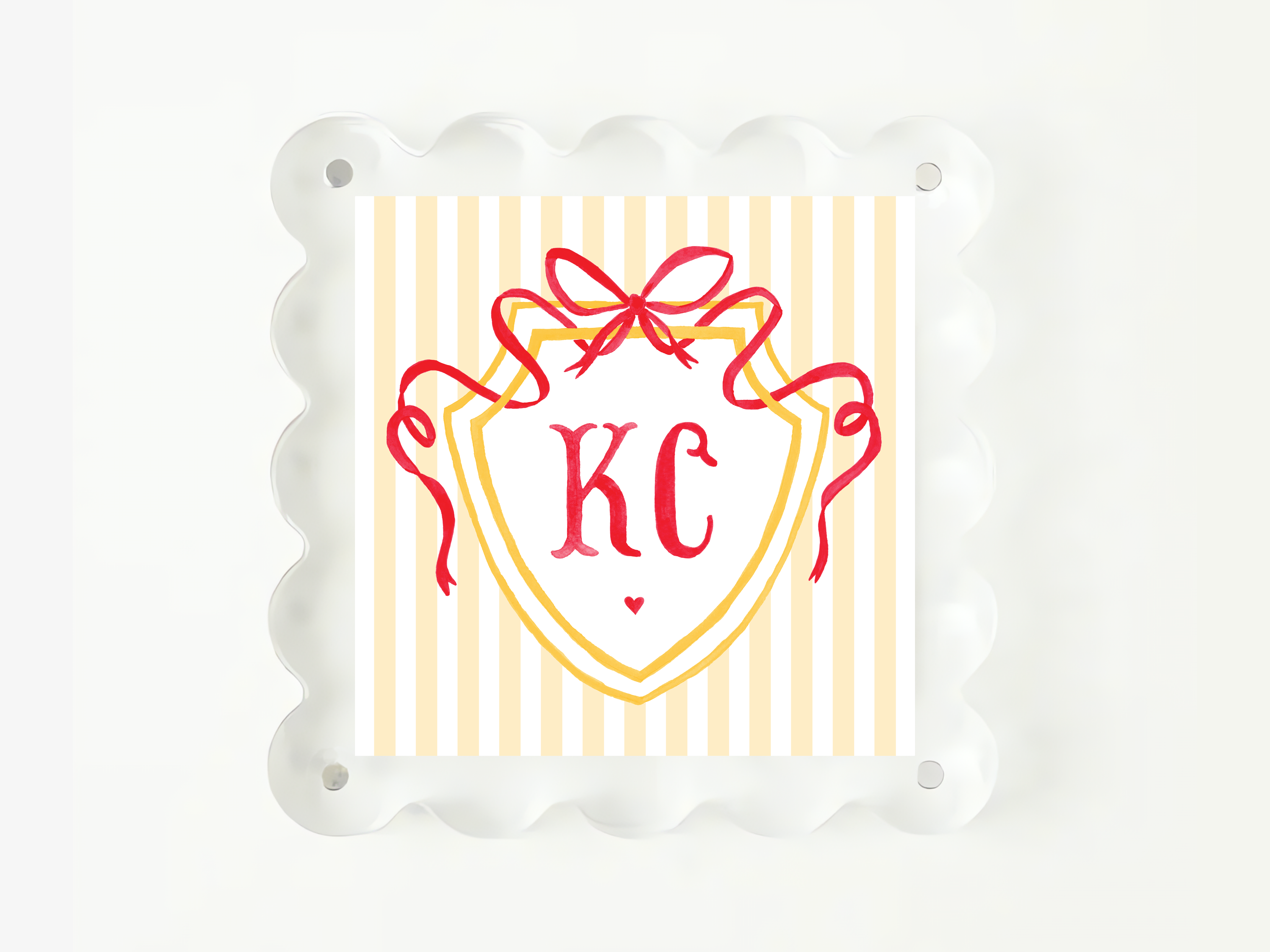 A square image with a decorative border, featuring a shield-shaped design with a red ribbon and the initials "KC" prominently displayed in the center.